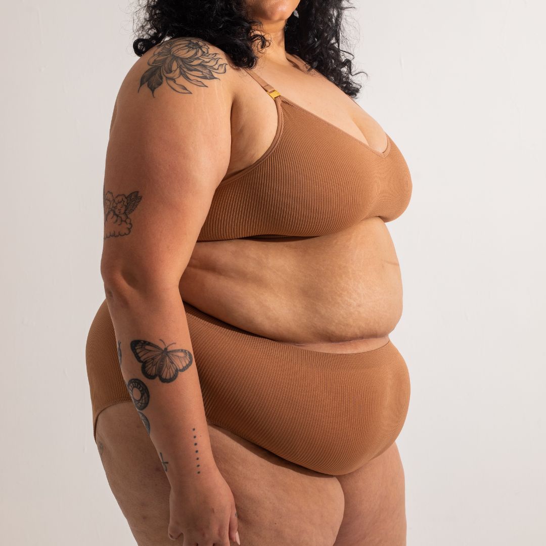 Sustainable nude 4 tan olive skin tone seam free high waist brief by Underwear for Humanity: ethical, sustainable. sizes 6-26. light, breathable, stretches across sizes. Models wear high-waisted underwear. underwear sits high on the waist, full seat coverage, Seam free underwear. made from recycled nylon