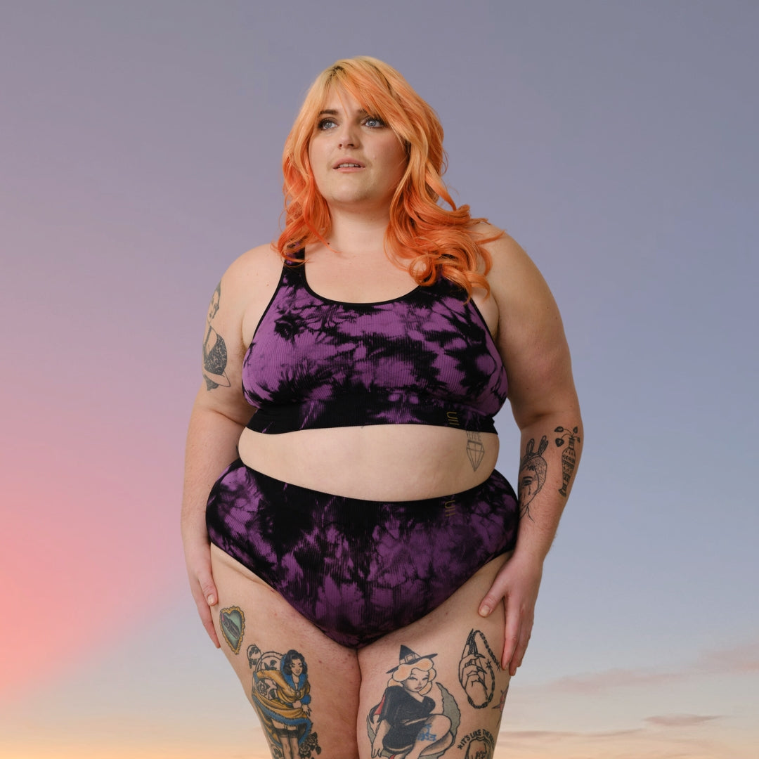 Sustainable, ethically produced black and orchid tie dye bra crop by Underwear for Humanity: stronger support for larger bust, D - GG cup sizes. Recycled materials, knitted bra and band, seamfree, made from recycled nylon. Models wear the D+ Crop