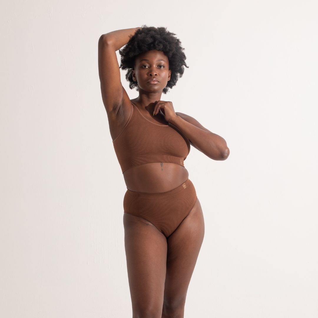 Sustainable nude 5 medium dark skin tone seam free high waist brief by Underwear for Humanity: ethical, sustainable. sizes 6-26. light, breathable, stretches across sizes. Models wear high-waisted underwear. underwear sits high on the waist, full seat coverage, Seam free underwear. made from recycled nylon