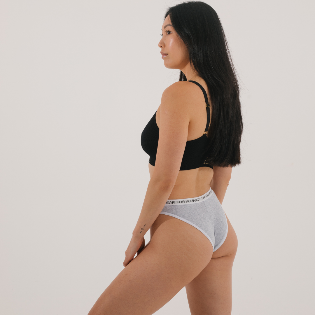 Underwear for Humanity, sustainable, organic and ethically made grey marle cotton underwear.  Soft , breathable, Cheeky coverage, sits high on hips. Model wears Cheeky Cotton underwear in grey marle with a white, recycled nylon elastic waist band.
