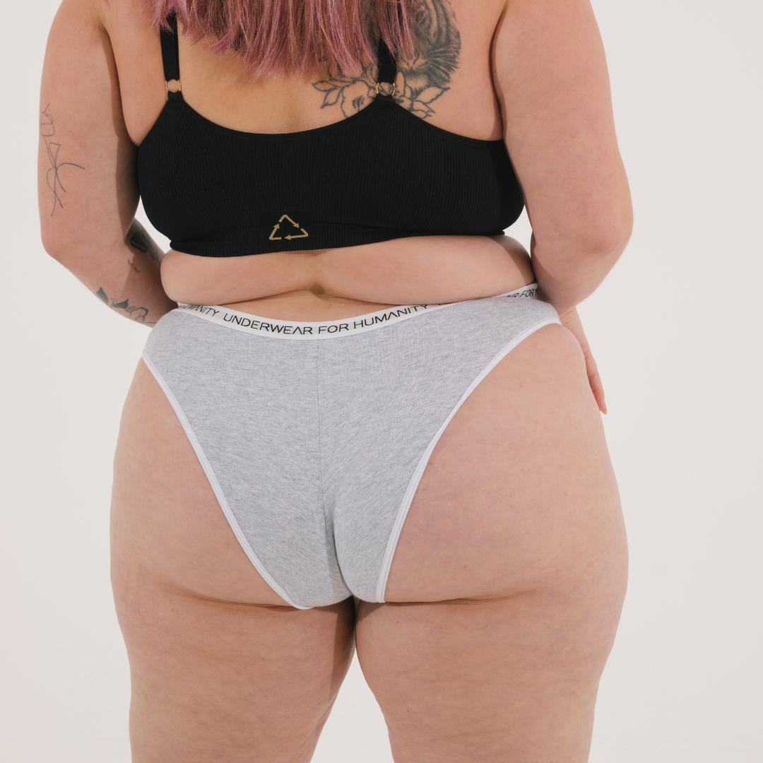 Underwear for Humanity, sustainable, organic and ethically made grey marle cotton underwear. Soft , breathable, Cheeky coverage, sits high on hips. Model wears Cheeky Cotton underwear in grey marle with a white, recycled nylon elastic waist band.