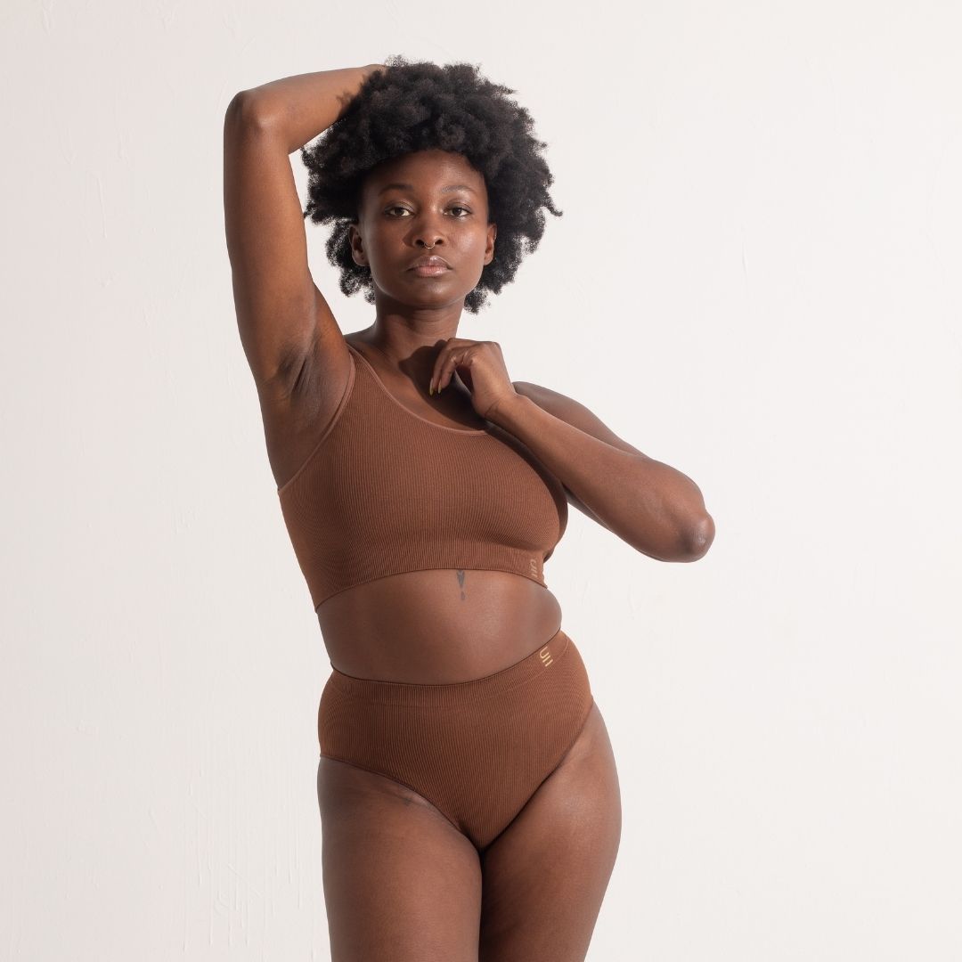 Sustainable, ethically produced Nude 5 - Medium dark skin bra crop by Underwear for Humanity: stronger support for larger bust, D - GG cup sizes. Recycled materials, knitted bra and band, seamfree, made from recycled nylon. Model wears the D+ Crop