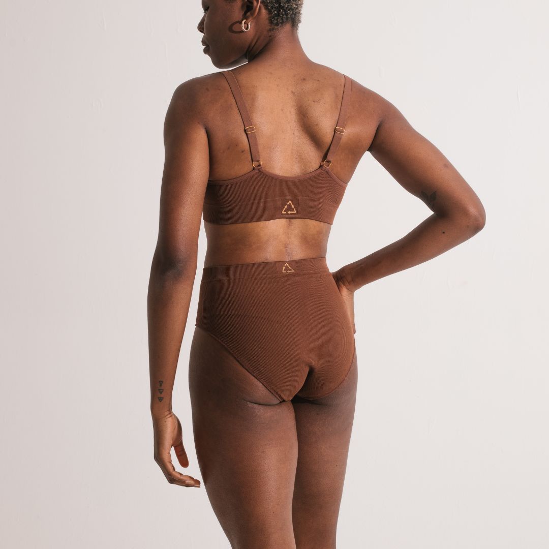 Sustainable nude 5 medium dark skin tone seam free high waist brief by Underwear for Humanity: ethical, sustainable. sizes 6-26. light, breathable, stretches across sizes. Models wear high-waisted underwear. underwear sits high on the waist, full seat coverage, Seam free underwear. made from recycled nylon