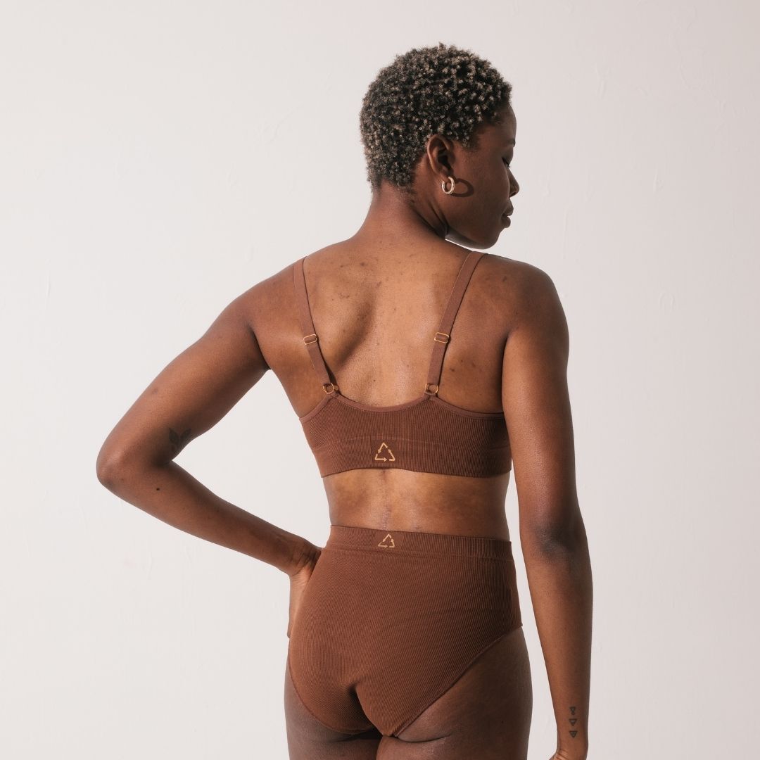 Sustainable, ethically produced nude 5 -medium dark skin tone wireless bra by Underwear for Humanity. For DD-GG cup sizes. Recycled materials, flexible, supportive. Knitted bra and band, adjustable straps. Model wears the DD+ bra.