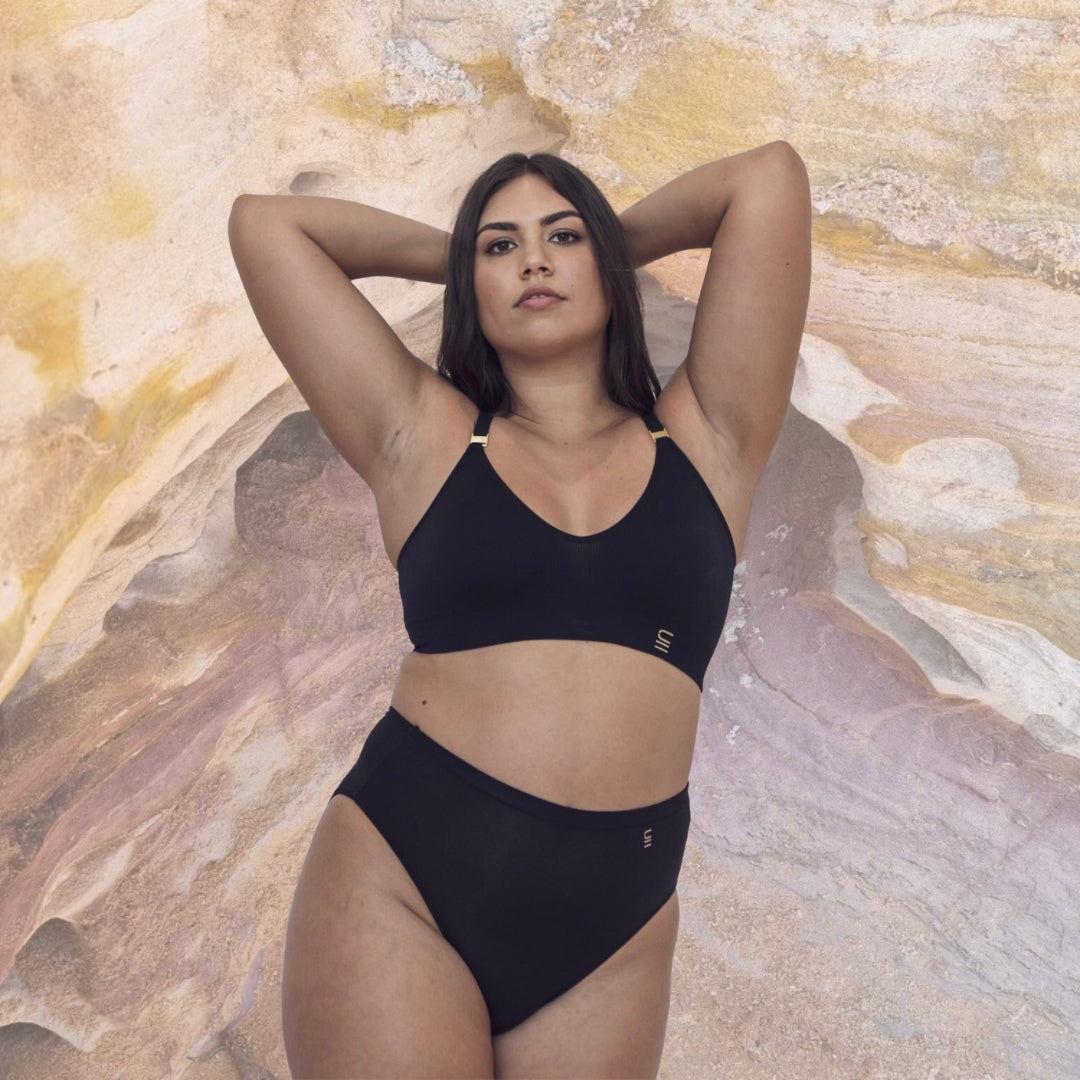 Sustainable Black wireless bra by Underwear For Humanity: ethical, sustainable. A -D cup sizes. Recycled materials, flexible, supportive. Knitted bra and band, adjustable straps. Model wears A-D bra
