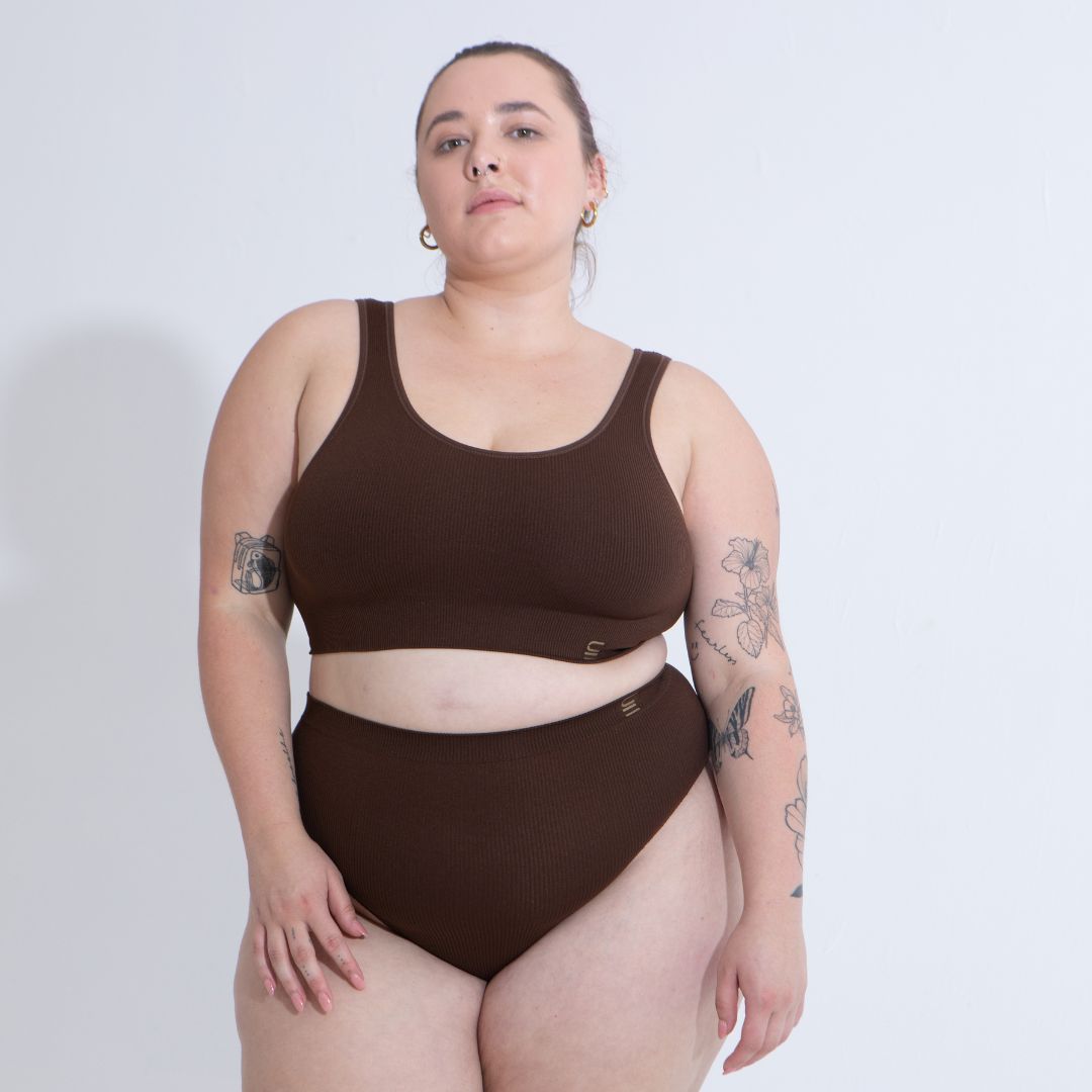 Sustainable nude 6- dark skin tone featured on light skin, seam free high waist brief by Underwear for Humanity: ethical, sustainable. sizes 6-26. light, breathable, stretches across sizes. Models wear high-waisted underwear. underwear sits high on the waist, full seat coverage, Seam free underwear. made from recycled nylon