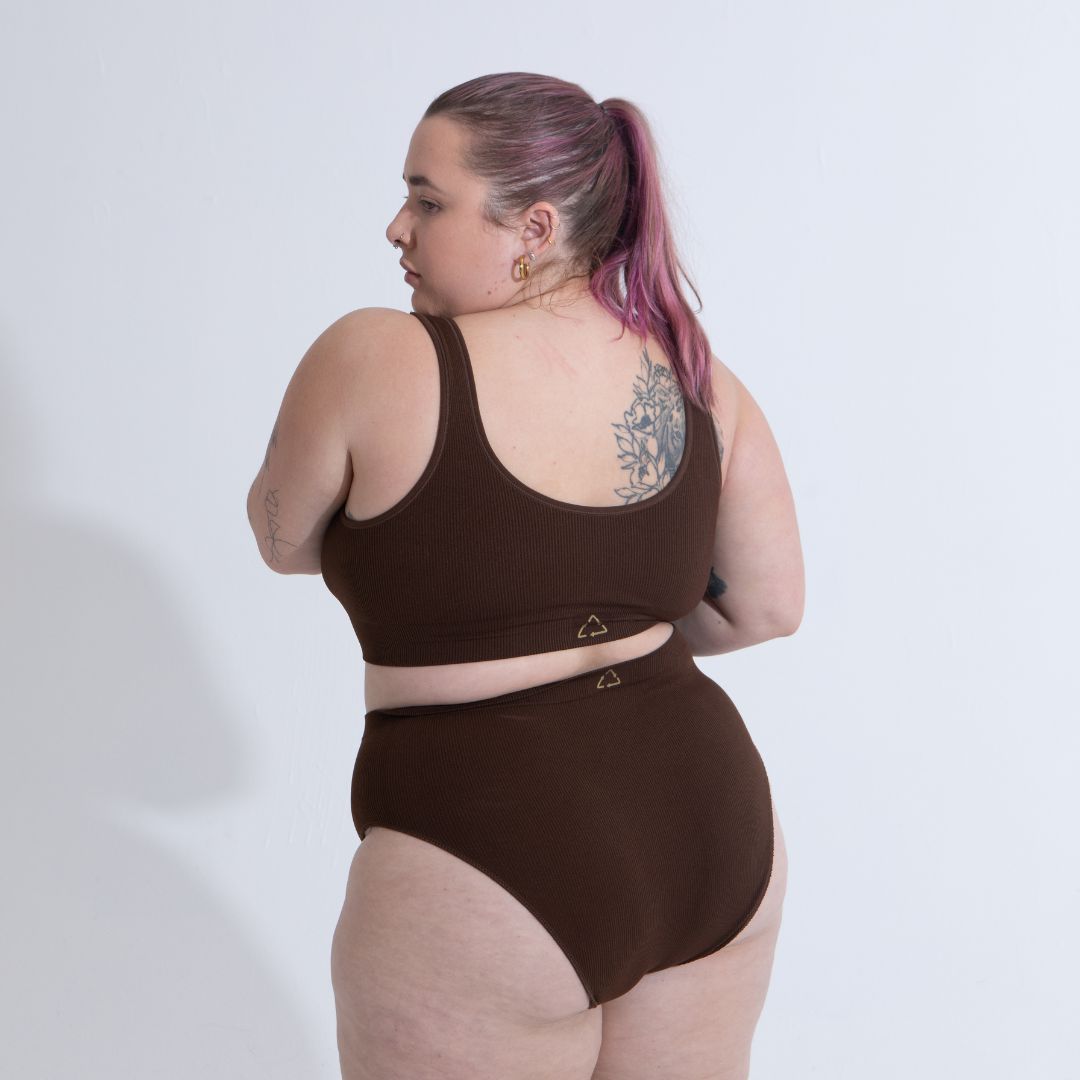 Sustainable nude 6- dark skin tone featured on light skin, seam free high waist brief by Underwear for Humanity: ethical, sustainable. sizes 6-26. light, breathable, stretches across sizes. Models wear high-waisted underwear. underwear sits high on the waist, full seat coverage, Seam free underwear. made from recycled nylon