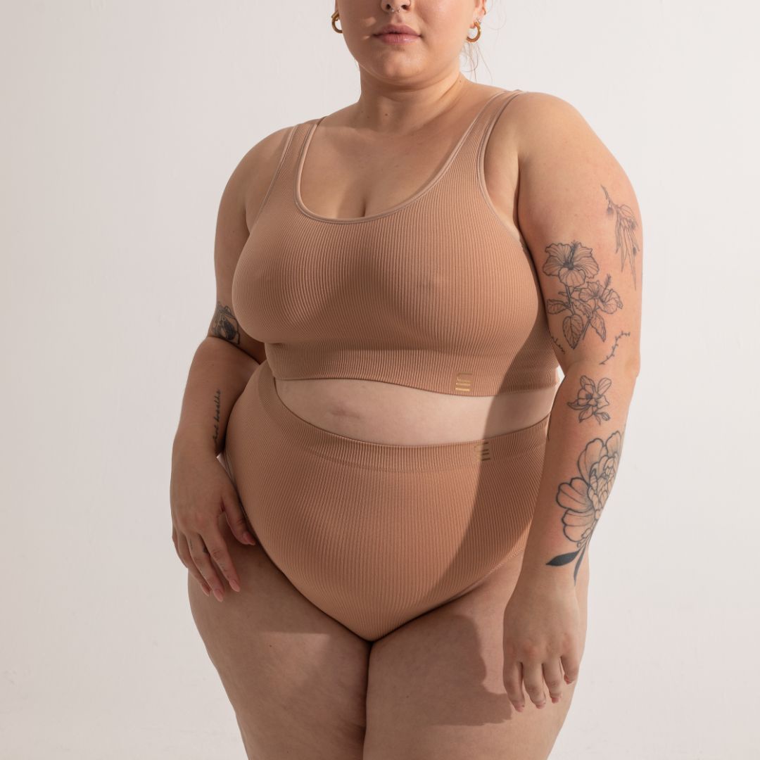 Sustainable, ethically made nude 3 - light beige skin tone, high waist seam free g-string by Underwear for Humanity: Flexible and comfortable, stretches across sizes. Models wear high-waisted G -string underwear. Underwear sits high on the waist, high on the seat, and smooth on the body, made from recycled nylon.