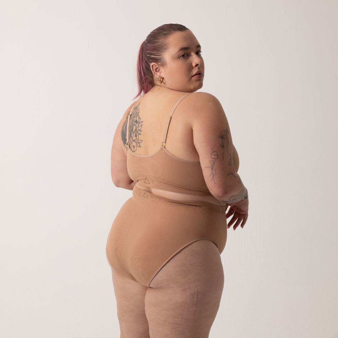 Sustainable, ethically made nude 3 - light beige skin tone, high waist seam free g-string by Underwear for Humanity: Flexible and comfortable, stretches across sizes. Models wear high-waisted G -string underwear. Underwear sits high on the waist, high on the seat, and smooth on the body, made from recycled nylon.