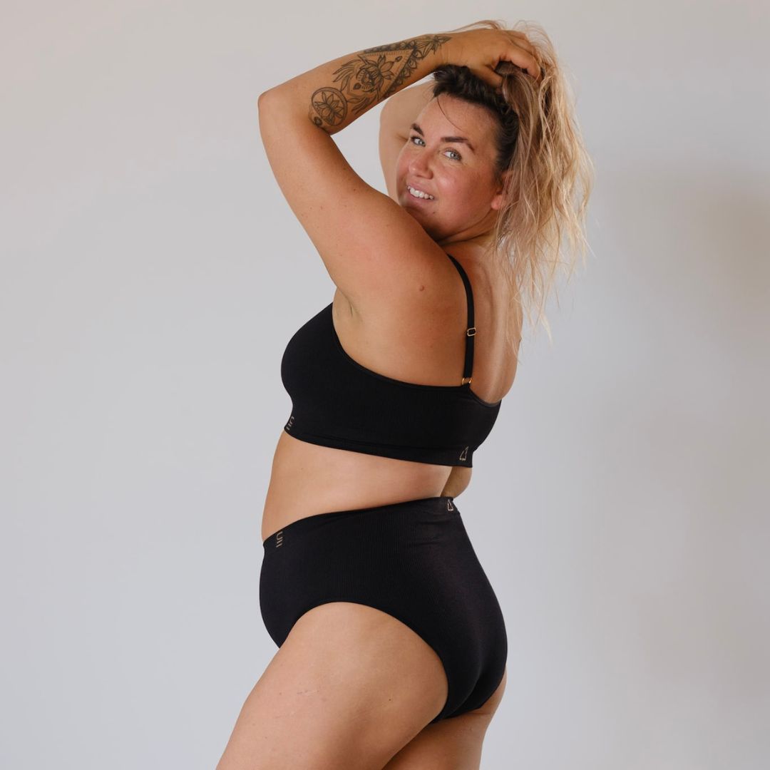 Sustainable, ethically made Black high waist seam free brief by Underwear for Humanity: Flexible and comfortable, stretches across sizes. Models wear high waisted ethical underwear. Underwear is made from recycled nylon and sits high on the waist, full seat coverage and smooth on the body.