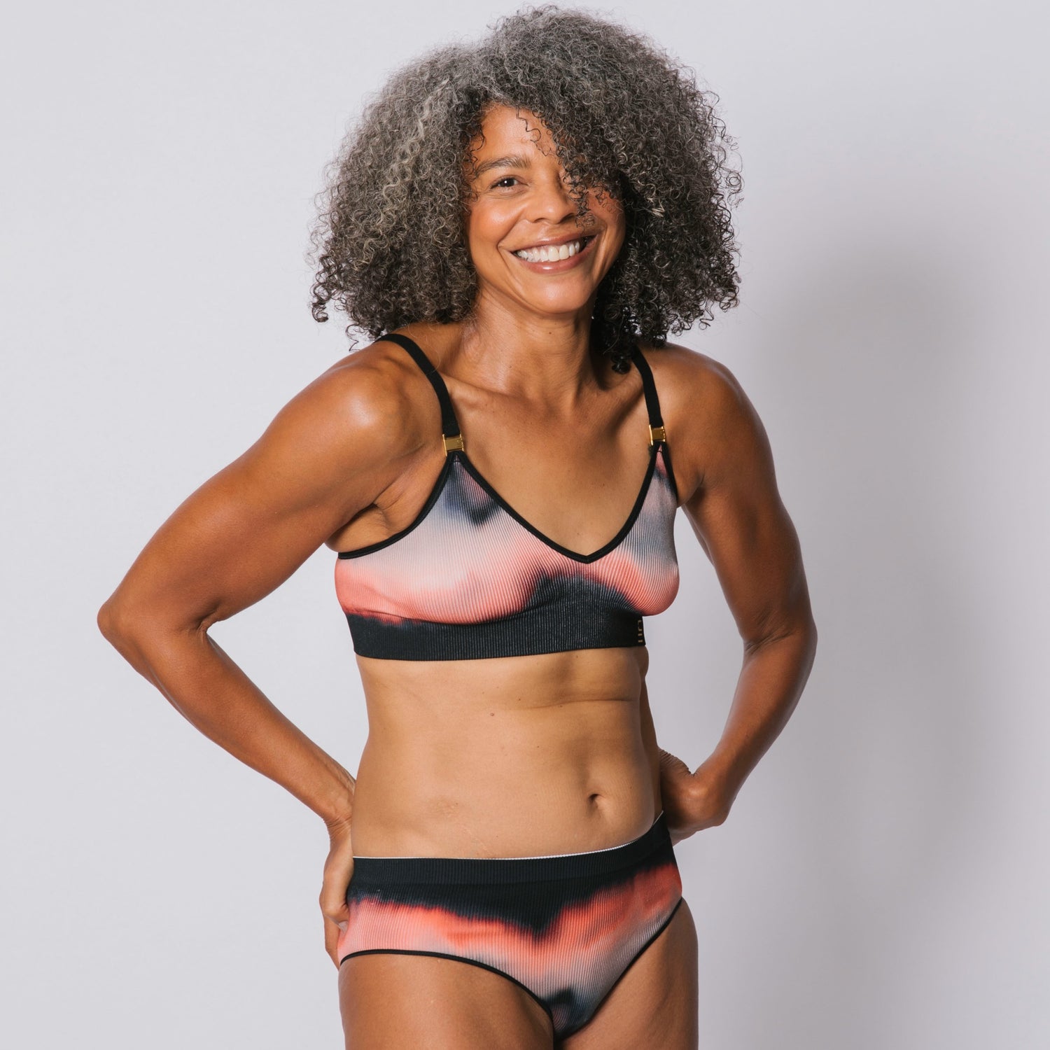 Underwear for Humanity, sustainable, organic and ethically made gradient underwear.  Soft , breathable, Cheeky coverage, sits high on hips. Model wears cheeky underwear in flame, recycled nylon elastic waist band.