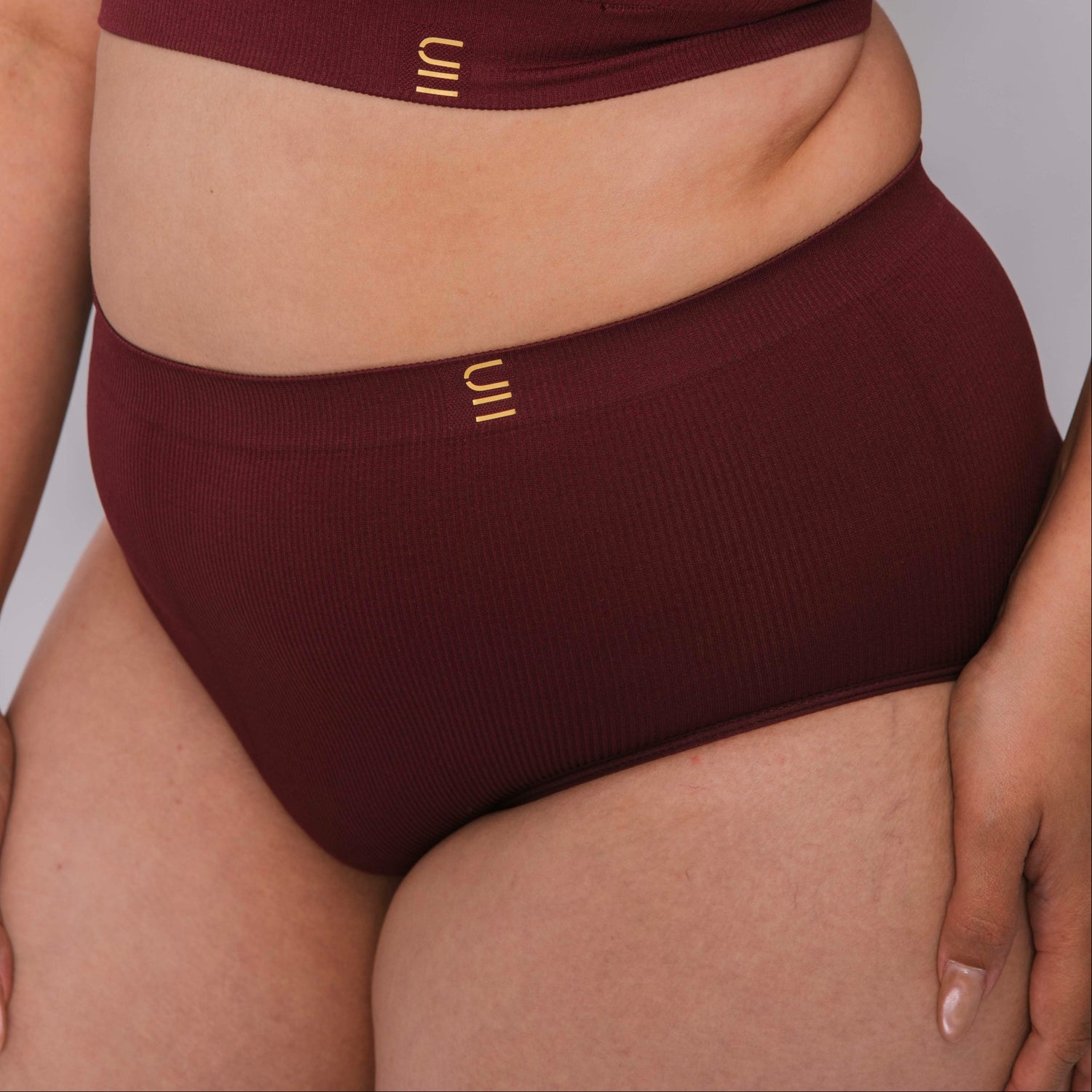 Sustainable, ethically made Cranberry high waist seam free brief by Underwear for Humanity: Flexible and comfortable, stretches across sizes. Models wear high waisted ethical underwear. Underwear is made from recycled nylon and sits high on the waist, full seat coverage and smooth on the body.