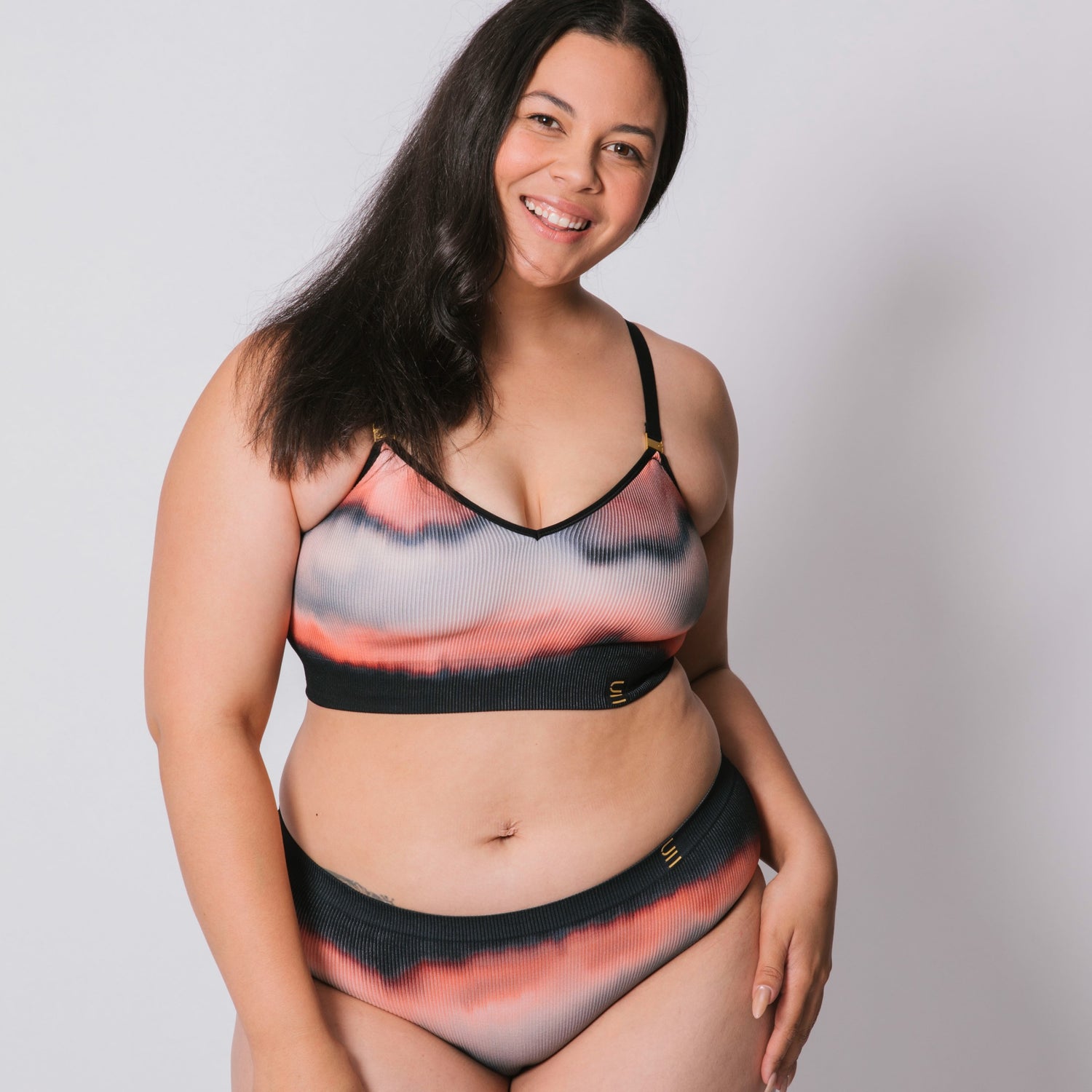 Underwear for Humanity, sustainable, organic and ethically made gradient underwear.  Soft , breathable, Cheeky coverage, sits high on hips. Model wears cheeky underwear in flame, recycled nylon elastic waist band.