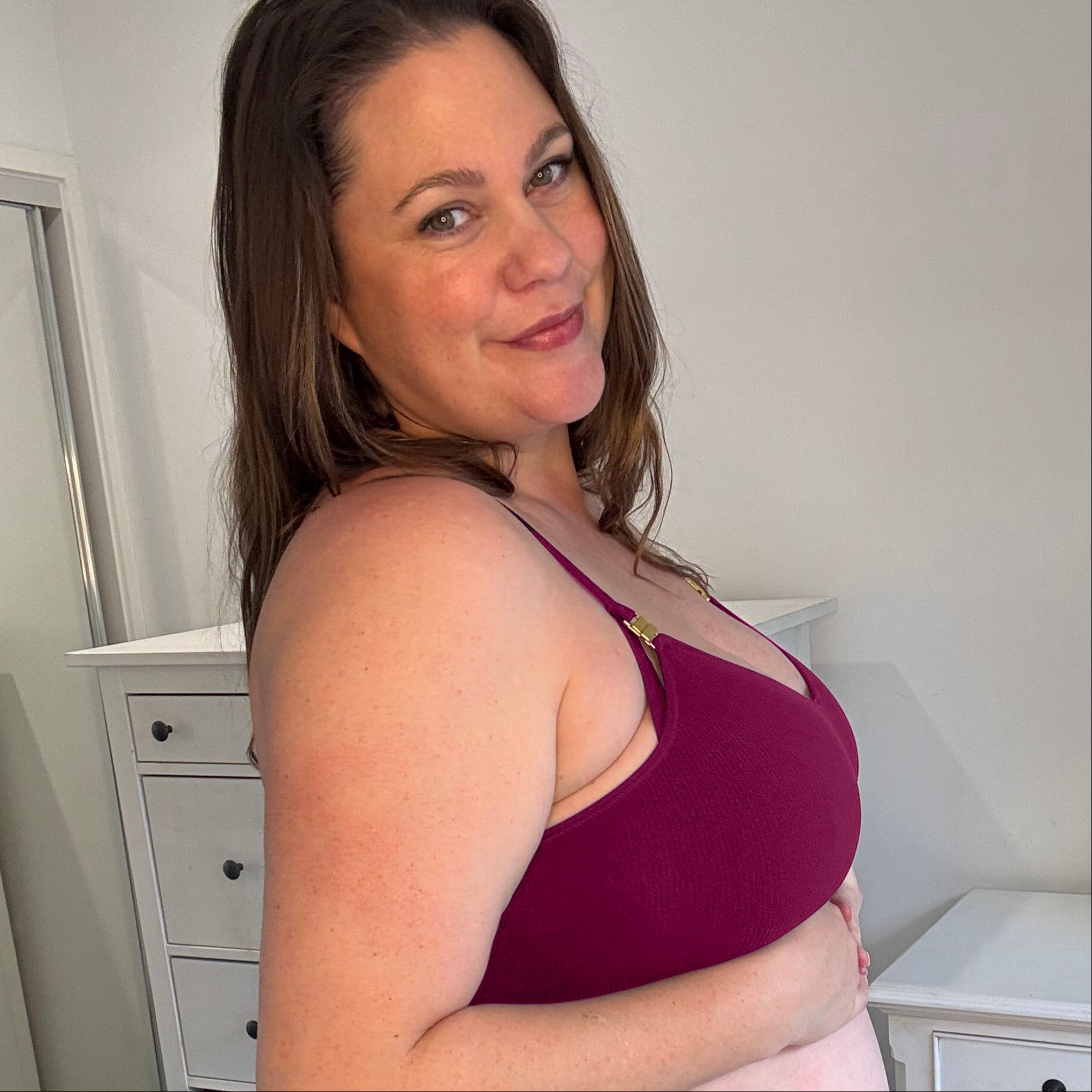 Sustainable, ethically made, cranberry wireless maternity bra by Underwear For Humanity. A -D and DD-GG cup sizes. Recycled materials, flexible, supportive, pregnancy, feeding, convertible. Knitted bra and band, adjustable straps. Model wears maternity bra