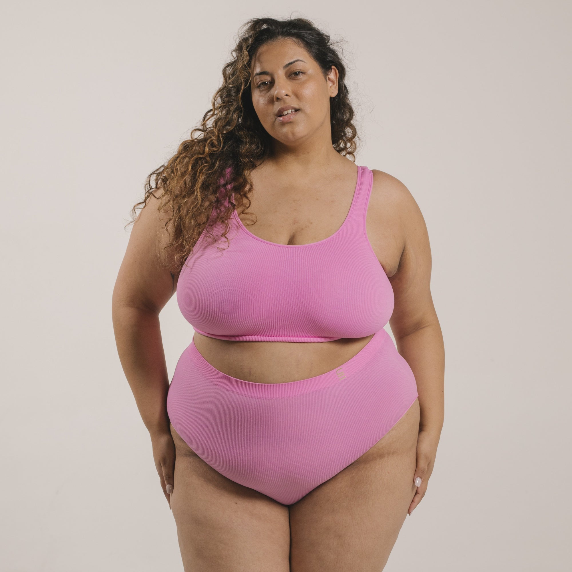 Sustainable pink high waist brief by Underwear for Humanity: ethical, sustainable. sizes 6-30 light, breathable. Models wear high-waisted underwear. underwear sits high on the waist, full seat coverage. smooth under clothing. made from Tencel and recycled materials, attached no-dig recycled elastic waist band.