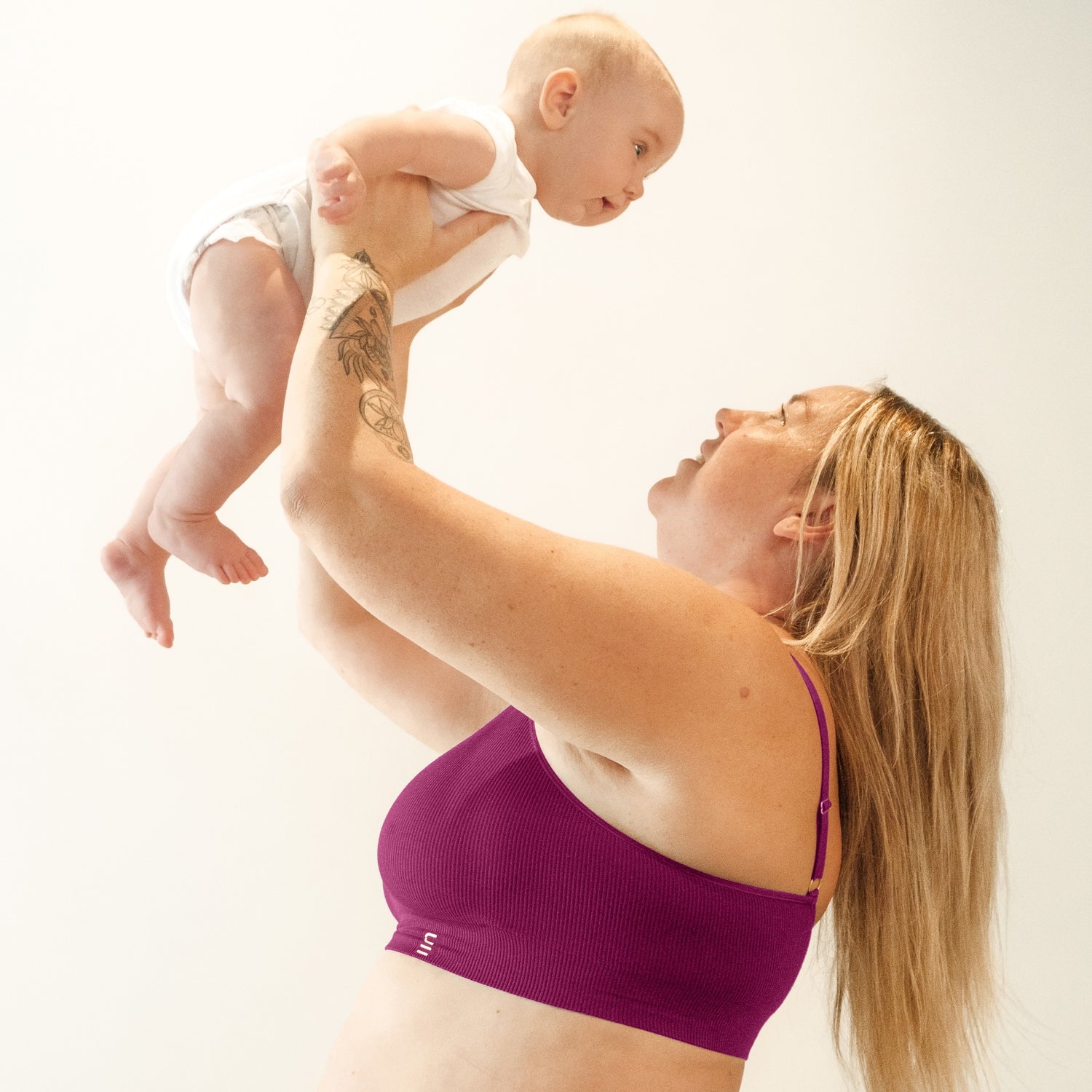 Sustainable, ethically made, cranberry wireless maternity bra by Underwear For Humanity. A -D and DD-GG cup sizes. Recycled materials, flexible, supportive, pregnancy, feeding, convertible. Knitted bra and band, adjustable straps. Model wears maternity bra