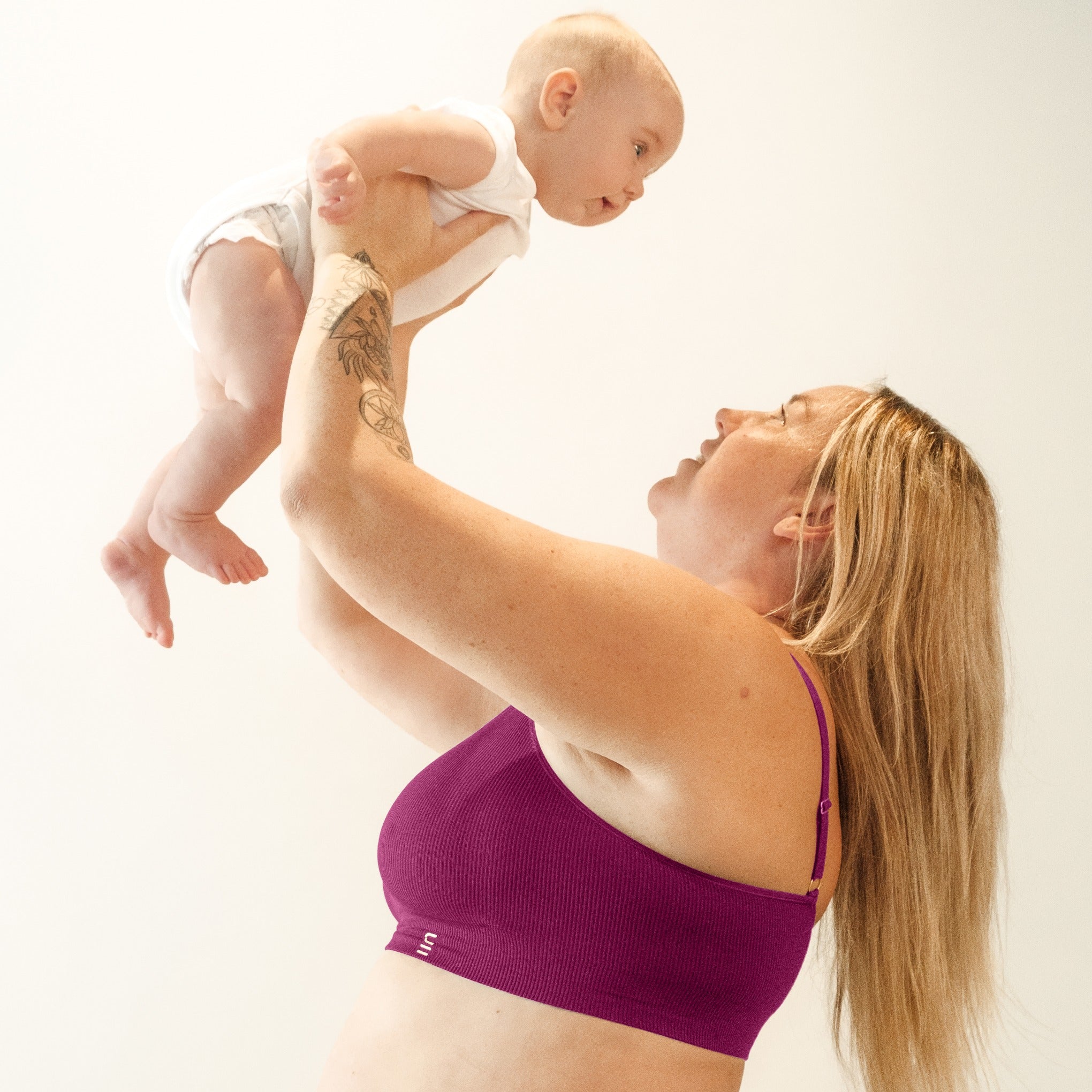 Sustainable, ethically made, cranberry wireless maternity bra by Underwear For Humanity. A -D and DD-GG cup sizes. Recycled materials, flexible, supportive, pregnancy, feeding, convertible. Knitted bra and band, adjustable straps. Model wears maternity bra