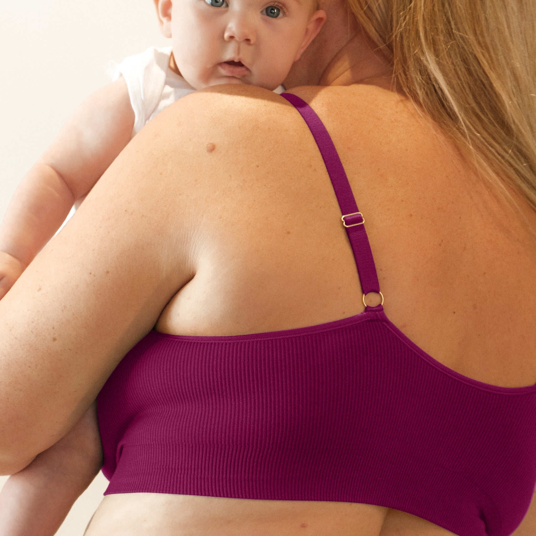 Sustainable, ethically made, cranberry wireless maternity bra by Underwear For Humanity. A -D and DD-GG cup sizes. Recycled materials, flexible, supportive, pregnancy, feeding, convertible. Knitted bra and band, adjustable straps. Model wears maternity bra