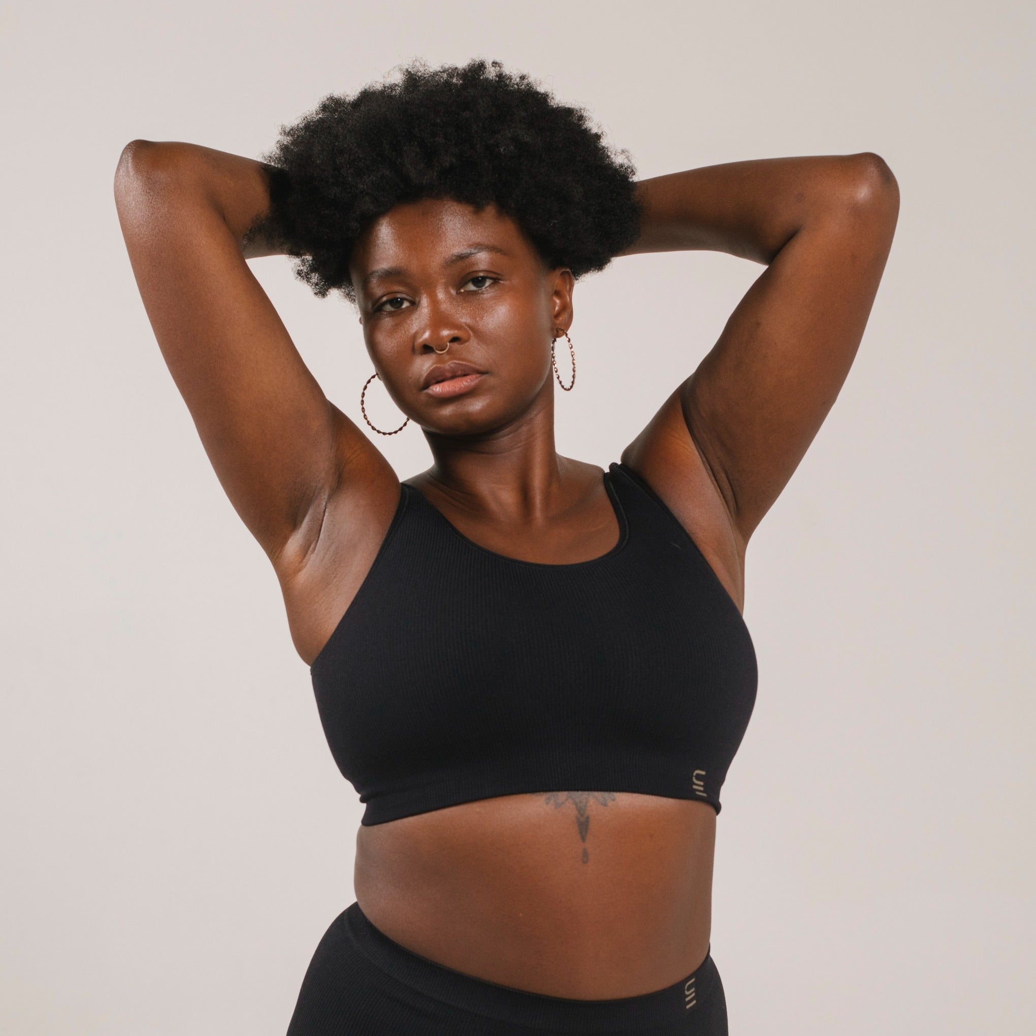 Sustainable, ethically produced Black bra crop by Underwear for Humanity: stronger support for larger bust, D - GG cup sizes. Recycled materials, knitted bra and band, seamfree, made from recycled nylon. Models wear the D+ Crop