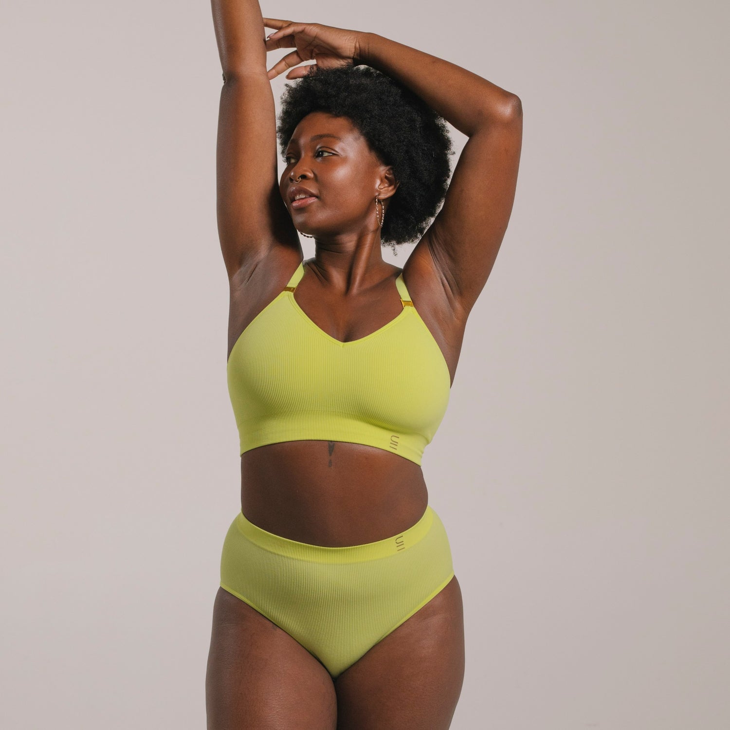 Sustainable, ethically produced lime wireless bra by Underwear for Humanity. For DD-GG cup sizes. Recycled materials, flexible, supportive. Knitted bra and band, adjustable straps. Model wears the DD+ bra.