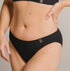 Ethically made recycled seam free black bikini brief by Underwear for Humanity: Flexible and comfortable, stretches across sizes. Models wear bikini brief underwear. Underwear is made from recycled nylon and sits low on the waist, full seat coverage and smooth on the body.