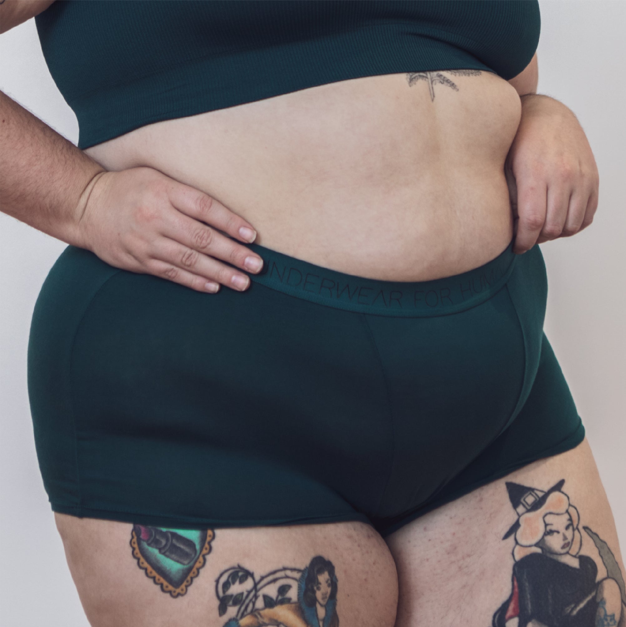 Sustainable, ethically produced atlantis shorts by Underwear for Humanity. Mid-rise, full coverage seat, thin, no-dig, elastic waist, short length sits higher on the leg. Made from sustainable tencel and recycled elastic. Models wear the shorts.