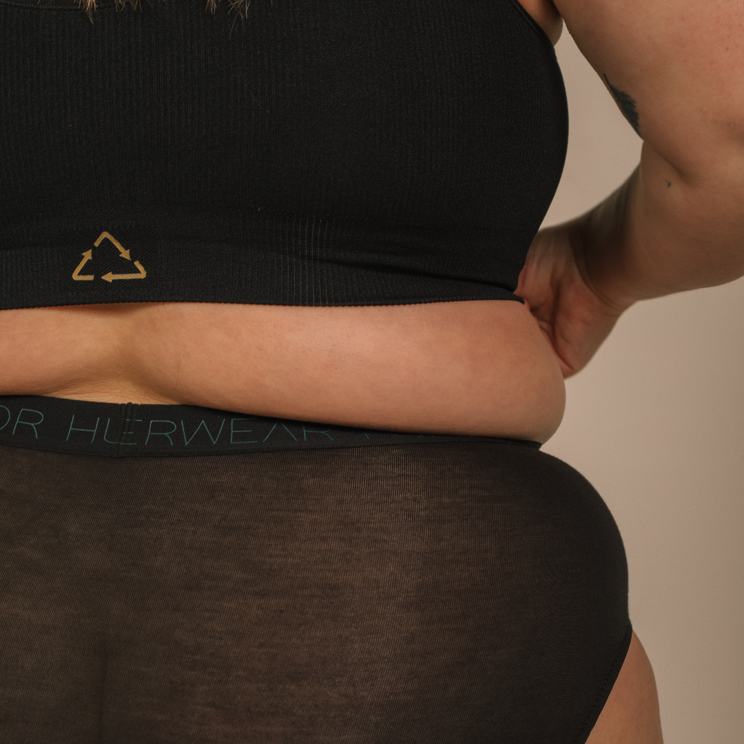 Sustainable black high waist brief by Underwear for Humanity: ethical, sustainable. sizes 6-30 light, breathable. Models wear high-waisted underwear. underwear sits high on the waist, full seat coverage. smooth under clothing. made from Tencel and recycled materials, attached no-dig recycled elastic waist band.