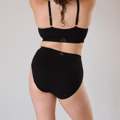 Sustainable, ethically made Black high waist seam free brief by Underwear for Humanity: Flexible and comfortable, stretches across sizes. Models wear high waisted ethical underwear. Underwear is made from recycled nylon and sits high on the waist, full seat coverage and smooth on the body.