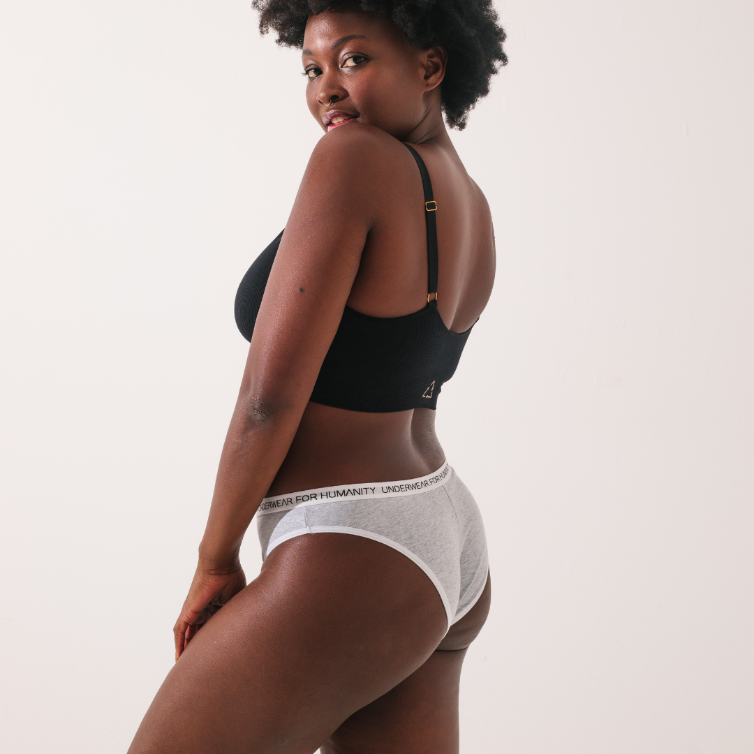 Underwear for Humanity, sustainable, organic and ethically made white cotton underwear.  Soft , breathable, Cheeky coverage, sits high on hips. Model wears Cheeky Cotton underwear in white with a white, recycled nylon elastic waist band. 