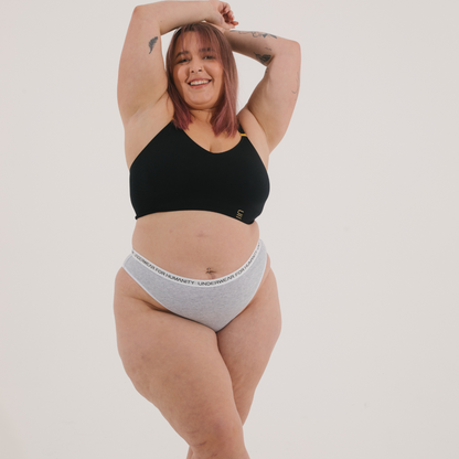 Underwear for Humanity, sustainable, organic and ethically made grey marle cotton underwear.  Soft , breathable, Cheeky coverage, sits high on hips. Model wears Cheeky Cotton underwear in grey marle with a white, recycled nylon elastic waist band.  