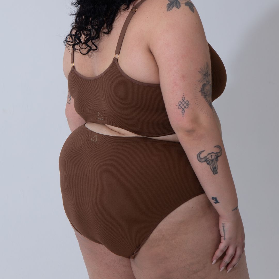 Sustainable nude 5 medium dark skin tone seam free high waist brief by Underwear for Humanity: ethical, sustainable. sizes 6-26. light, breathable, stretches across sizes. Models wear high-waisted underwear. underwear sits high on the waist, full seat coverage, Seam free underwear. made from recycled nylon