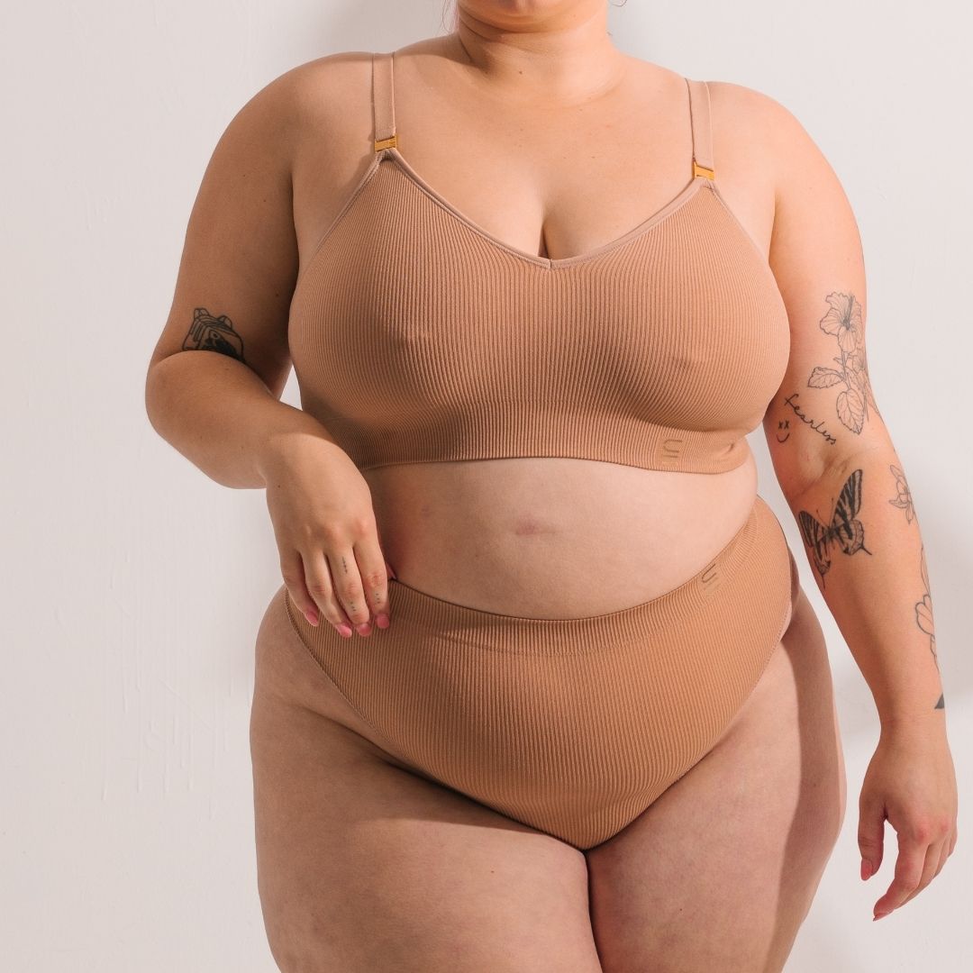 Sustainable, ethically made Nude 3 light beige skin tone high waist seam free g-string by Underwear for Humanity: Flexible and comfortable, stretches across sizes. Models wear high-waisted G -string underwear. Underwear sits high on the waist, high on the seat, and smooth on the body, made from recycled nylon.
