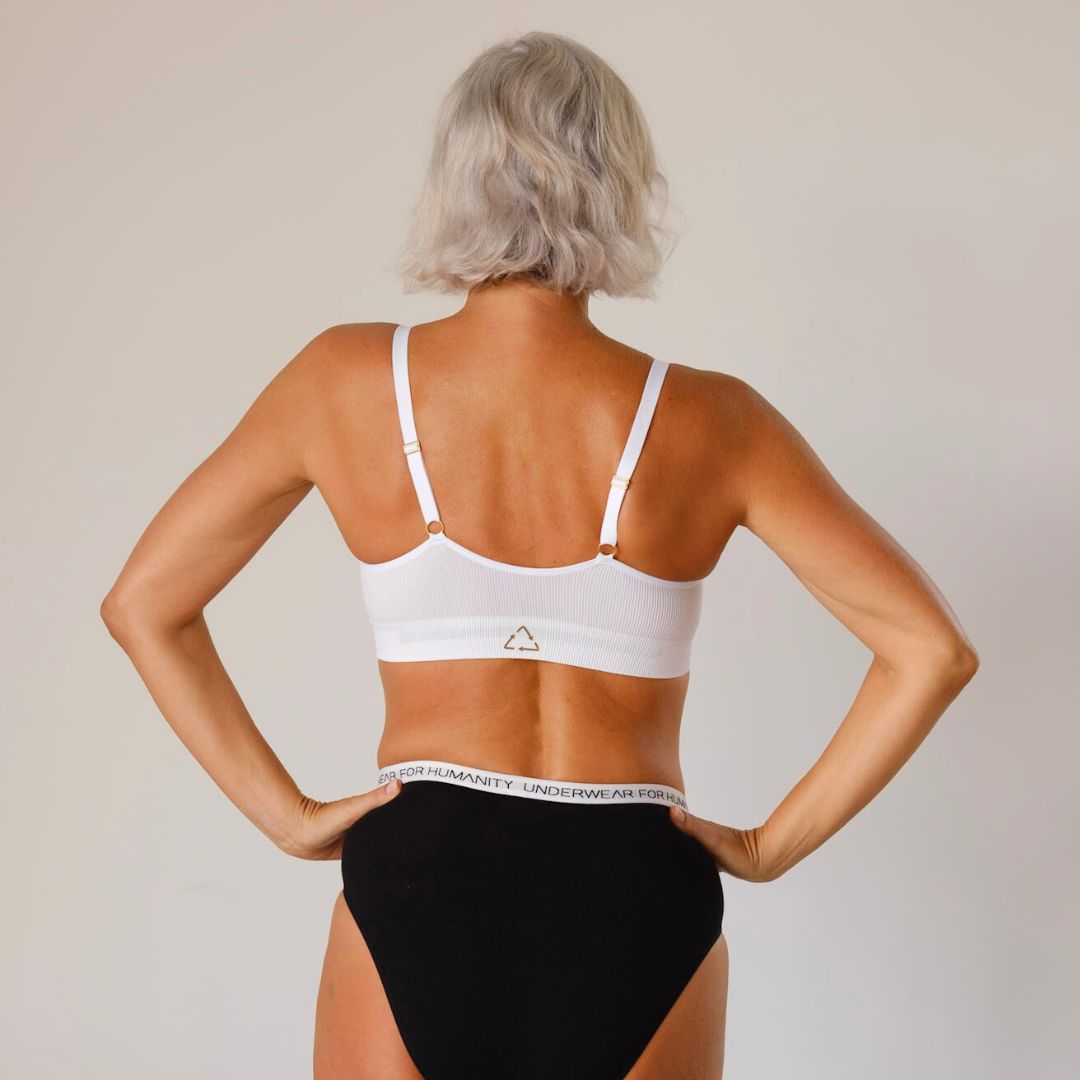 Sustainable, ethically produced White wireless bra by Underwear for Humanity. A -D cup sizes. Recycled materials, flexible, supportive. Knitted bra and band, adjustable straps. Models wear the A-D bra.
