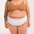 Underwear for Humanity, sustainable, organic and ethically made white cotton underwear. Soft , breathable, full coverage, sits high on waist. Model wears High waisted Cotton underwear in white with a white, recycled nylon elastic waist band.