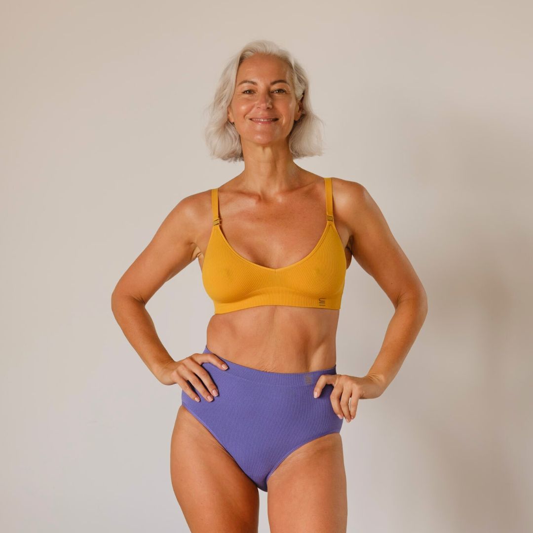 Sustainable, ethically produced Gold wireless bra by Underwear for Humanity. A -D cup sizes. Recycled materials, flexible, supportive. Knitted bra and band, adjustable straps. Models wear the A-D bra.
