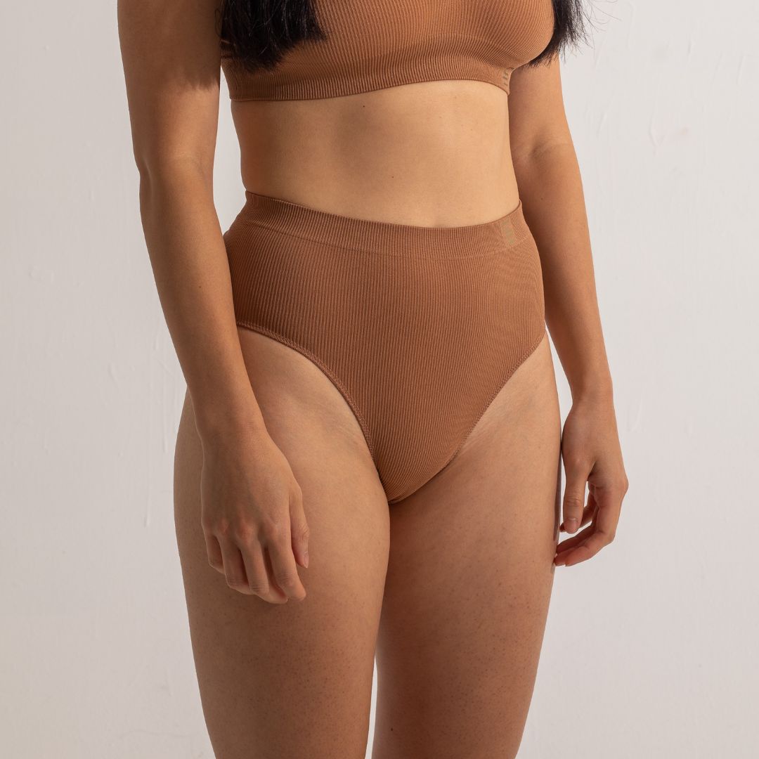Sustainable nude 4 tan olive skin tone seam free high waist brief by Underwear for Humanity: ethical, sustainable. sizes 6-26. light, breathable, stretches across sizes. Models wear high-waisted underwear. underwear sits high on the waist, full seat coverage, Seam free underwear. made from recycled nylon