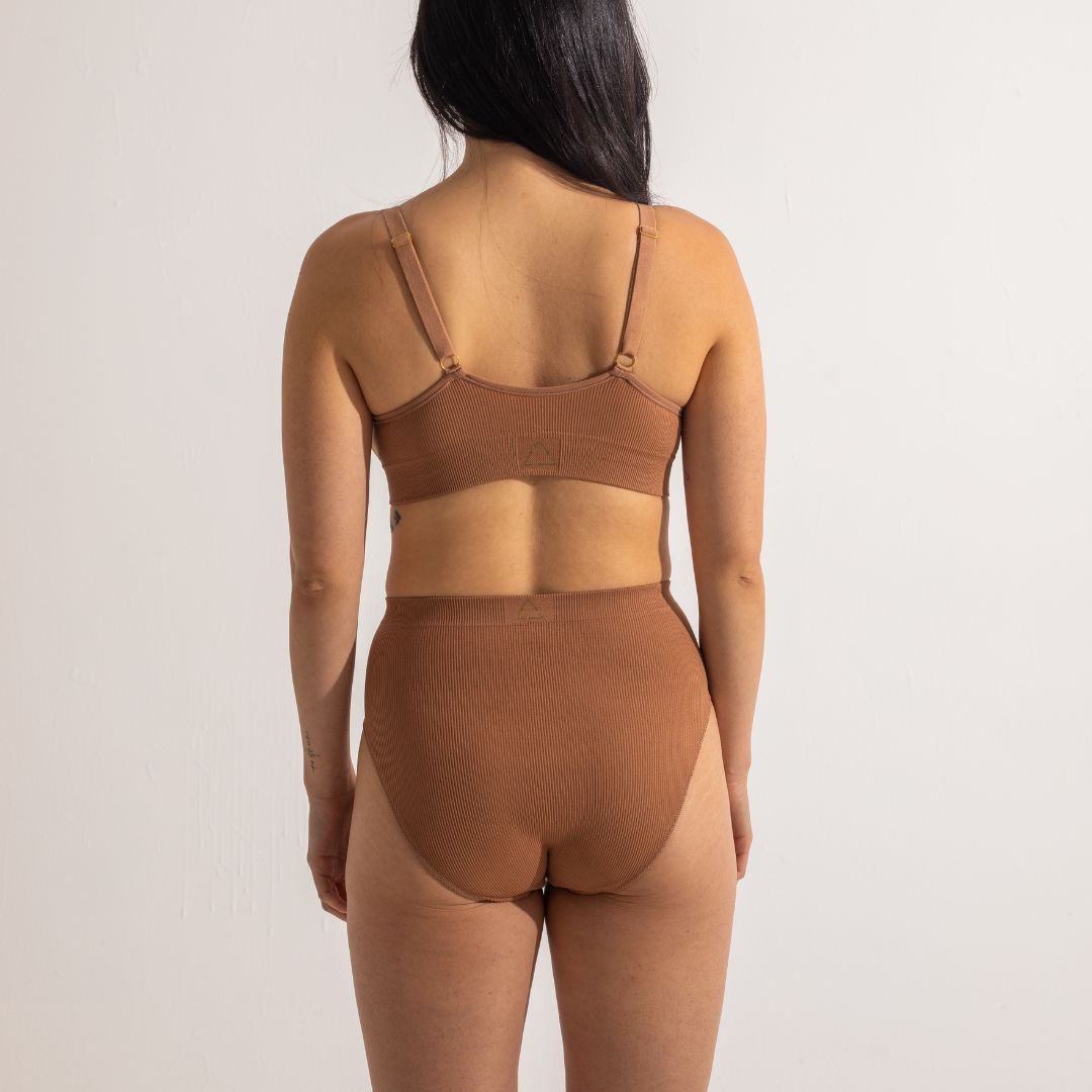 Sustainable nude 4 tan olive skin tone seam free high waist brief by Underwear for Humanity: ethical, sustainable. sizes 6-26. light, breathable, stretches across sizes. Models wear high-waisted underwear. underwear sits high on the waist, full seat coverage, Seam free underwear. made from recycled nylon