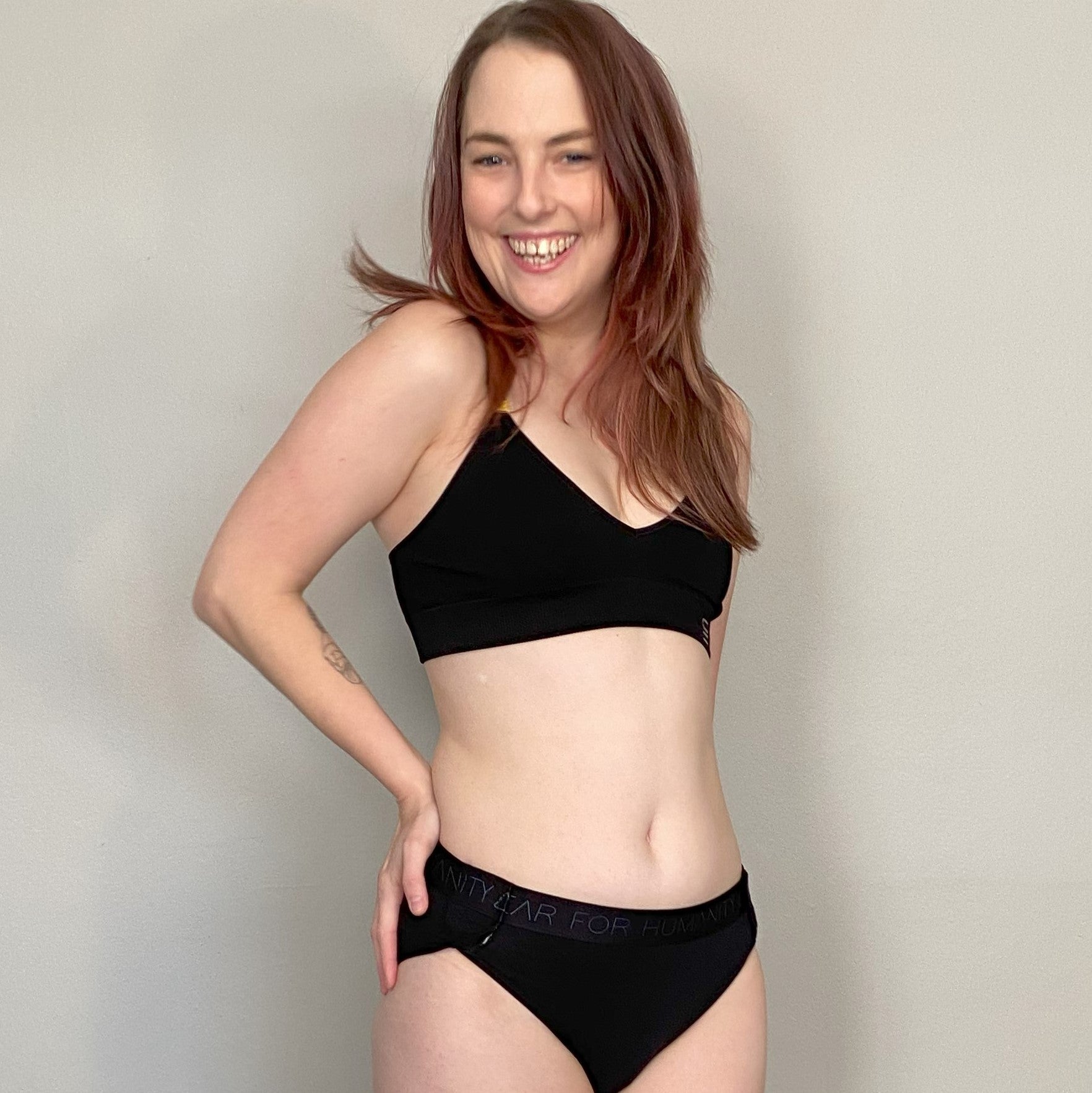 Madeleine wears the adaptive brief in black. the adaptive brief in black. made from organic cotton. high rise at the back for wheelchair users. soft velcro attachments at side. easy to take on and off. sustainable and ethically made adaptive underwear.