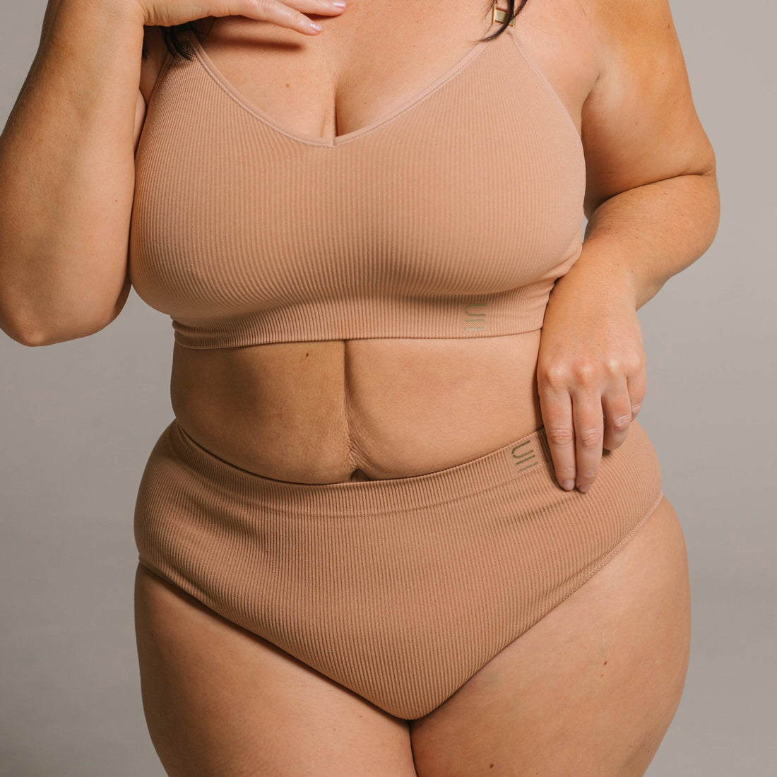 Sustainable, ethically made nude 3 - light beige skin tone, high waist seam free g-string by Underwear for Humanity: Flexible and comfortable, stretches across sizes. Models wear high-waisted G -string underwear. Underwear sits high on the waist, high on the seat, and smooth on the body, made from recycled nylon. 