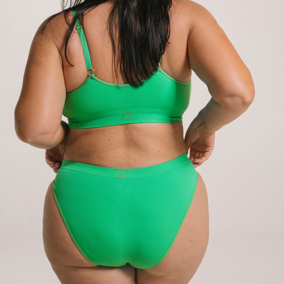 Ethically made recycled seam free apple bikini brief by Underwear for Humanity: Flexible and comfortable, stretches across sizes. Models wear bikini brief underwear. Underwear is made from recycled nylon and sits low on the waist, full seat coverage and smooth on the body.