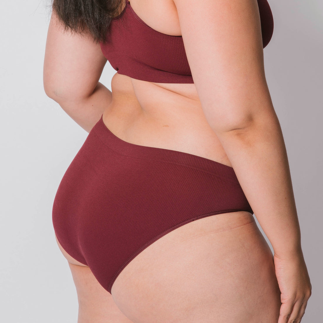 Sustainable, ethically made Cranberry high waist seam free brief by Underwear for Humanity: Flexible and comfortable, stretches across sizes. Models wear high waisted ethical underwear. Underwear is made from recycled nylon and sits high on the waist, full seat coverage and smooth on the body.