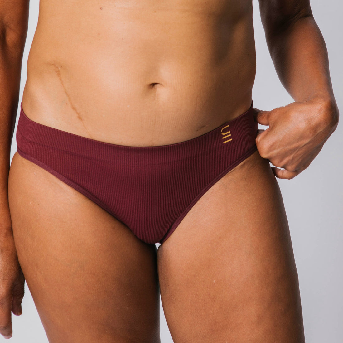 Sustainable, ethically made Cranberry high waist seam free brief by Underwear for Humanity: Flexible and comfortable, stretches across sizes. Models wear high waisted ethical underwear. Underwear is made from recycled nylon and sits high on the waist, full seat coverage and smooth on the body.