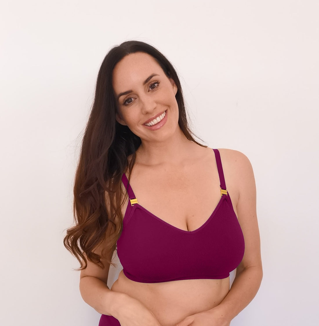 Sustainable, ethically made, cranberry wireless maternity bra by Underwear For Humanity. A -D and DD-GG cup sizes. Recycled materials, flexible, supportive, pregnancy, feeding, convertible. Knitted bra and band, adjustable straps. Model wears maternity bra