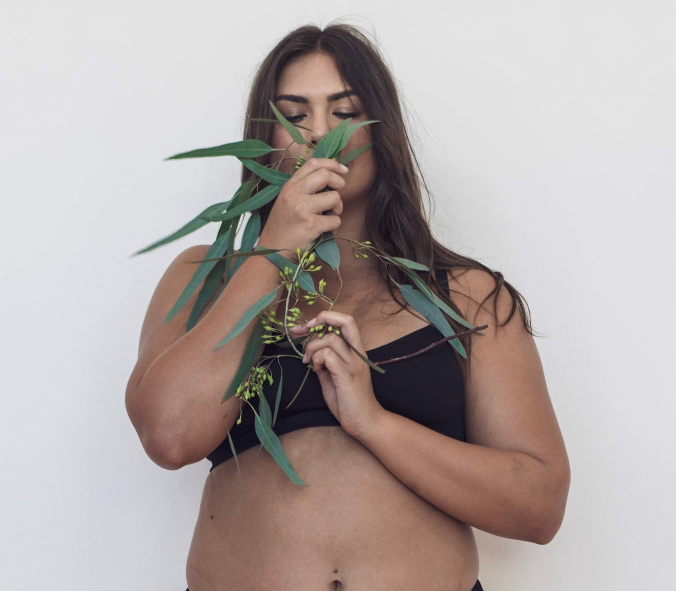 Woman holding leaves to her nose and smelling them