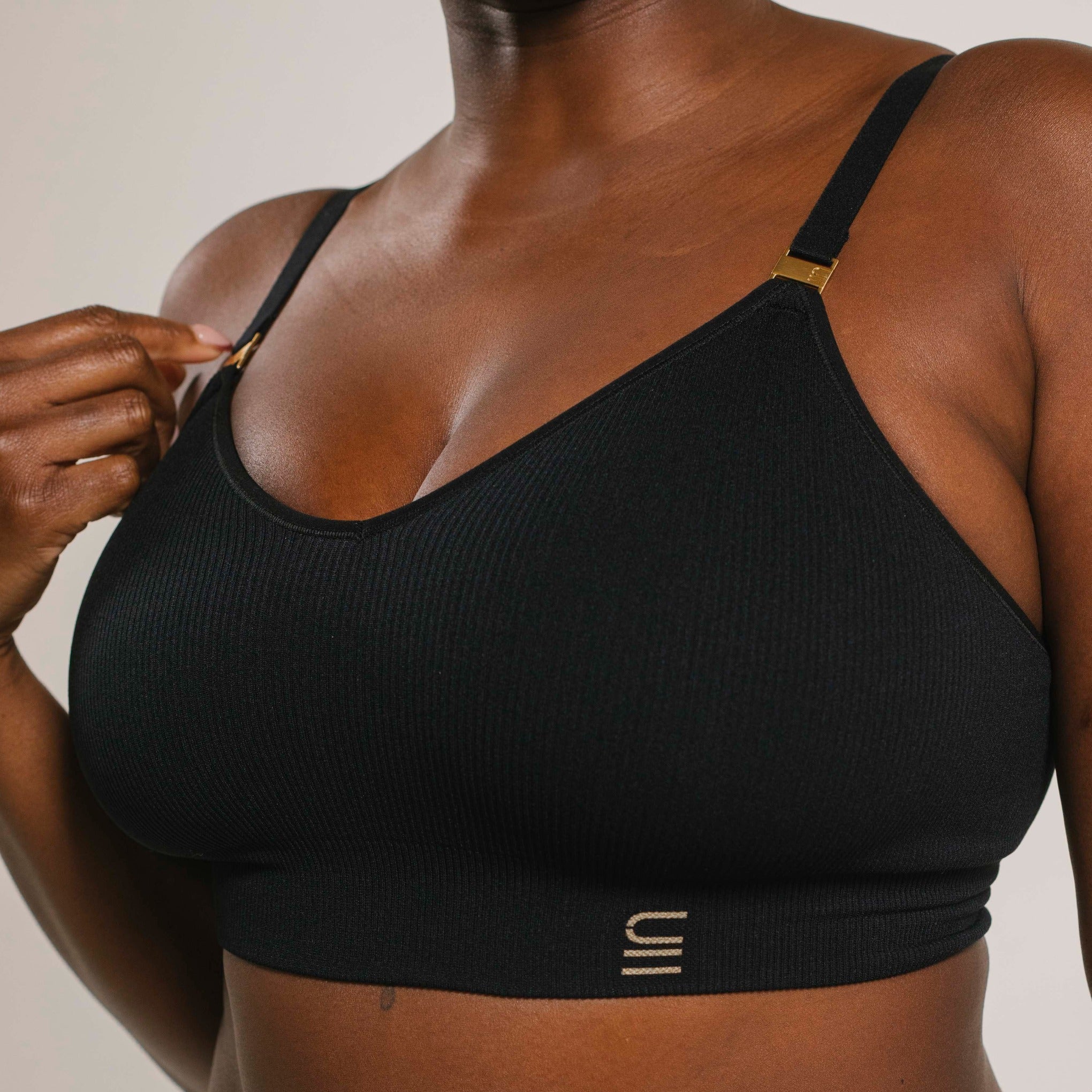 Sustainable, ethically produced black wireless bra by Underwear for Humanity. For DD-GG cup sizes. Recycled materials, flexible, supportive. Knitted bra and band, adjustable straps. Model wears the DD+ bra.