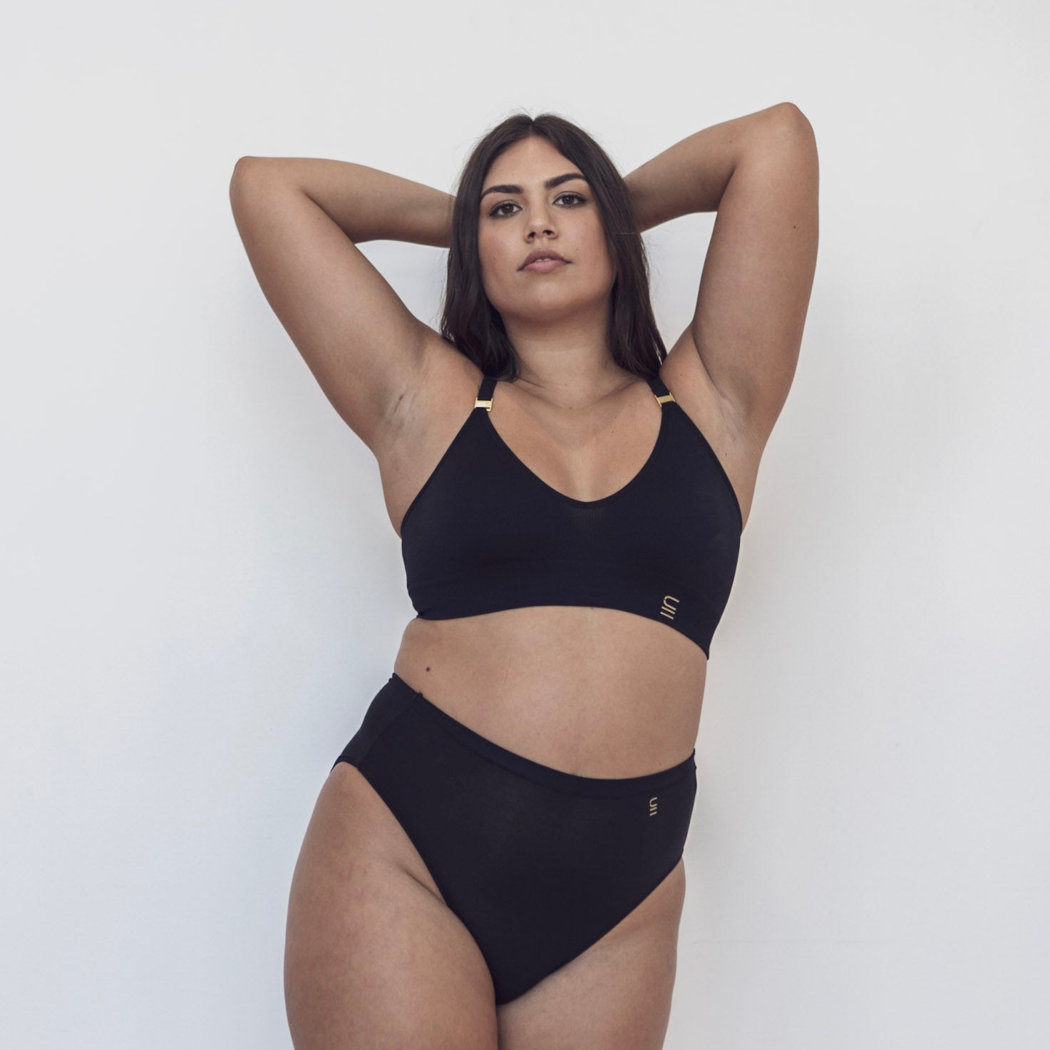 Sustainable Black wireless bra by Underwear For Humanity: ethical, sustainable. A -D cup sizes. Recycled materials, flexible, supportive. Knitted bra and band, adjustable straps. Model wears A-D bra