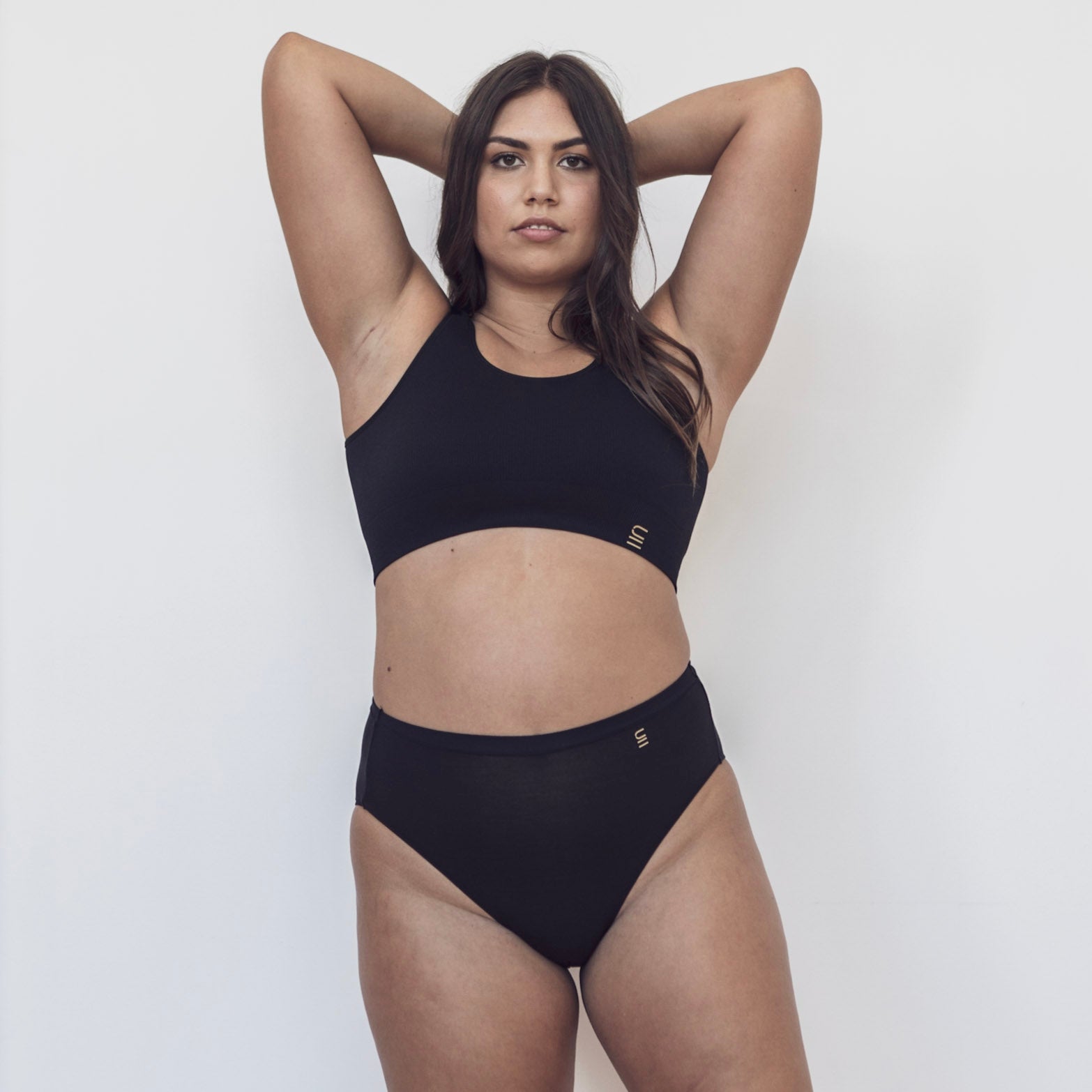 Sustainable black high waist brief by Underwear for Humanity: ethical, sustainable. sizes 6-26. light, breathable. Models wear high-waisted underwear. underwear sits high on the waist, full seat coverage. smooth under clothing. made from Tencel and recycled materials