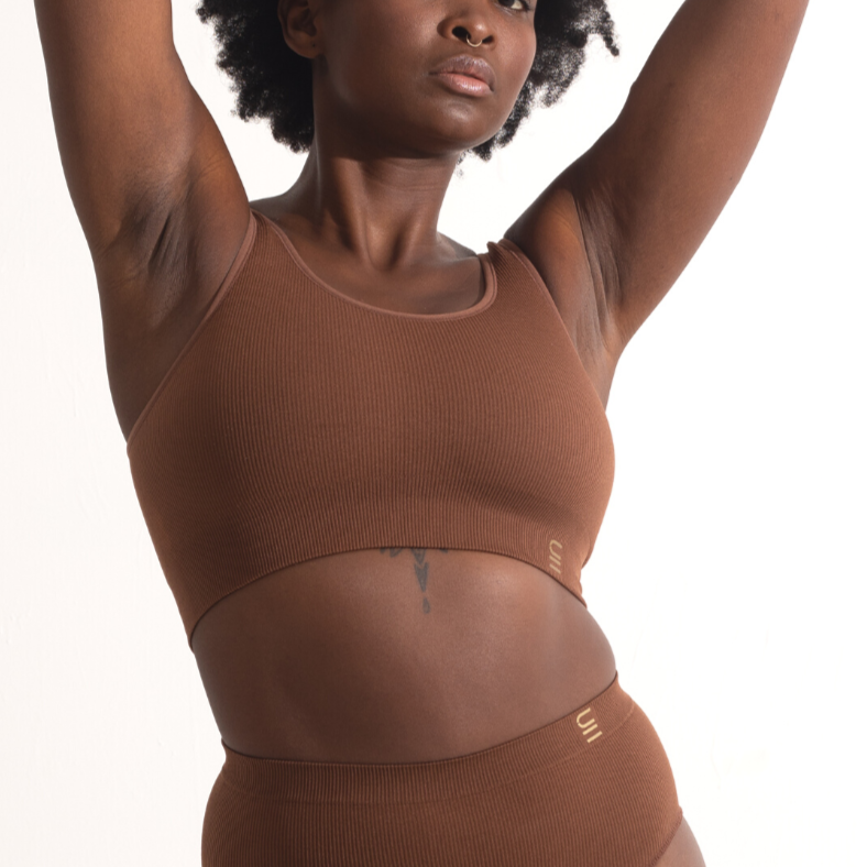 Sustainable, ethically produced Nude 5 - Medium dark skin bra crop by Underwear for Humanity: stronger support for larger bust, D - GG cup sizes. Recycled materials, knitted bra and band, seamfree, made from recycled nylon. Model wears the D+ Crop