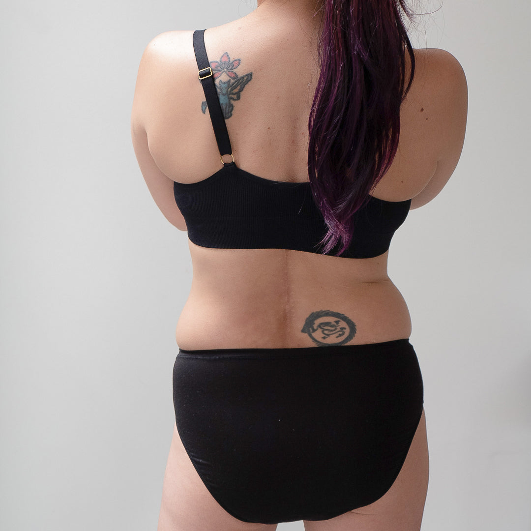 Sustainable, ethically made black wee or period undies. Absorbent without bulk. 1 day worth of wear or 3 tampons worth of protection. Suitable for day time use only. Toxin free, naturally antibacterial. Model wears daytime wee or period undies.