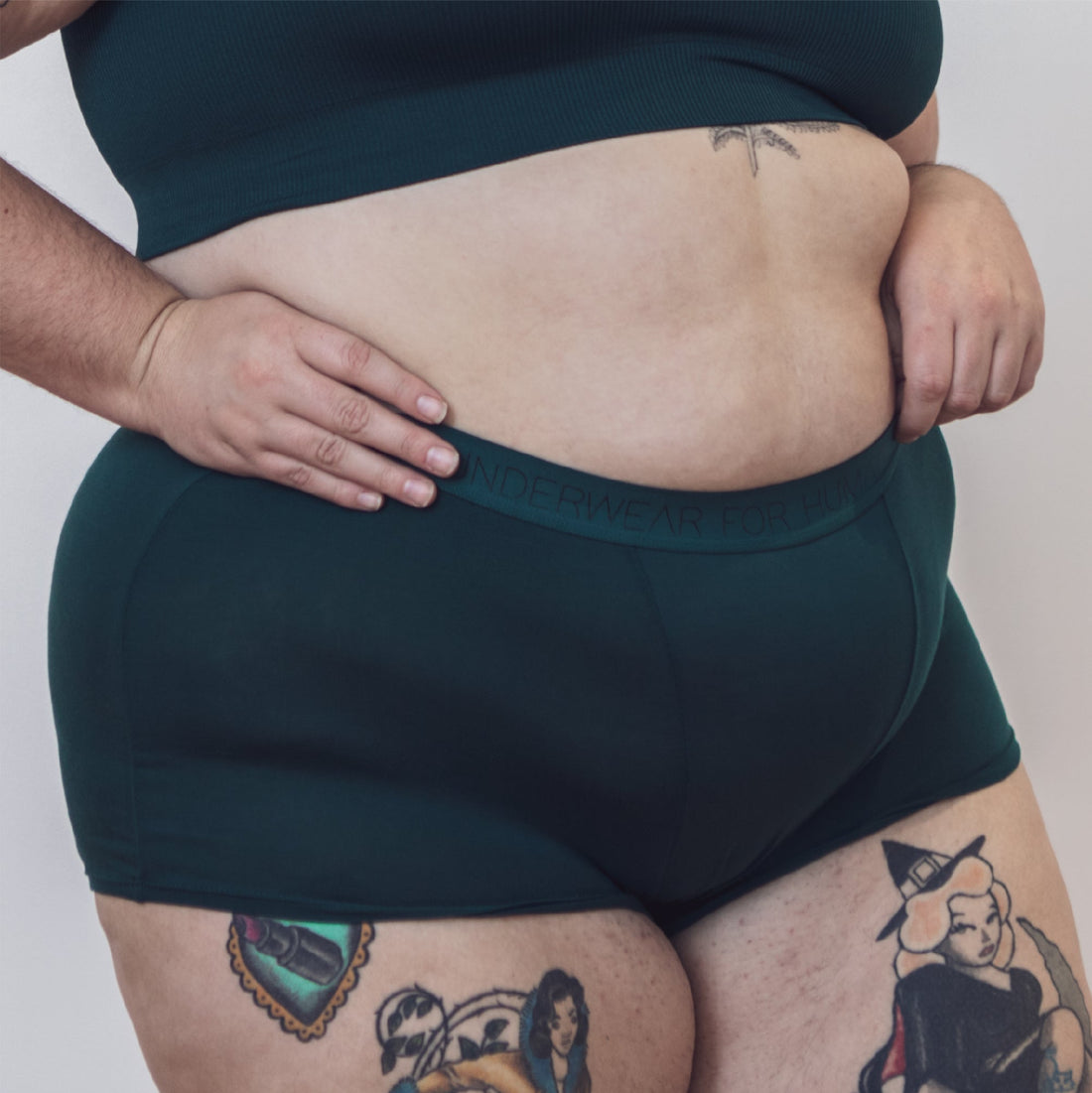 Sustainable, ethically produced atlantis shorts by Underwear for Humanity. Mid-rise, full coverage seat, thin, no-dig, elastic waist, short length sits higher on the leg. Made from sustainable tencel and recycled elastic. Models wear the shorts.